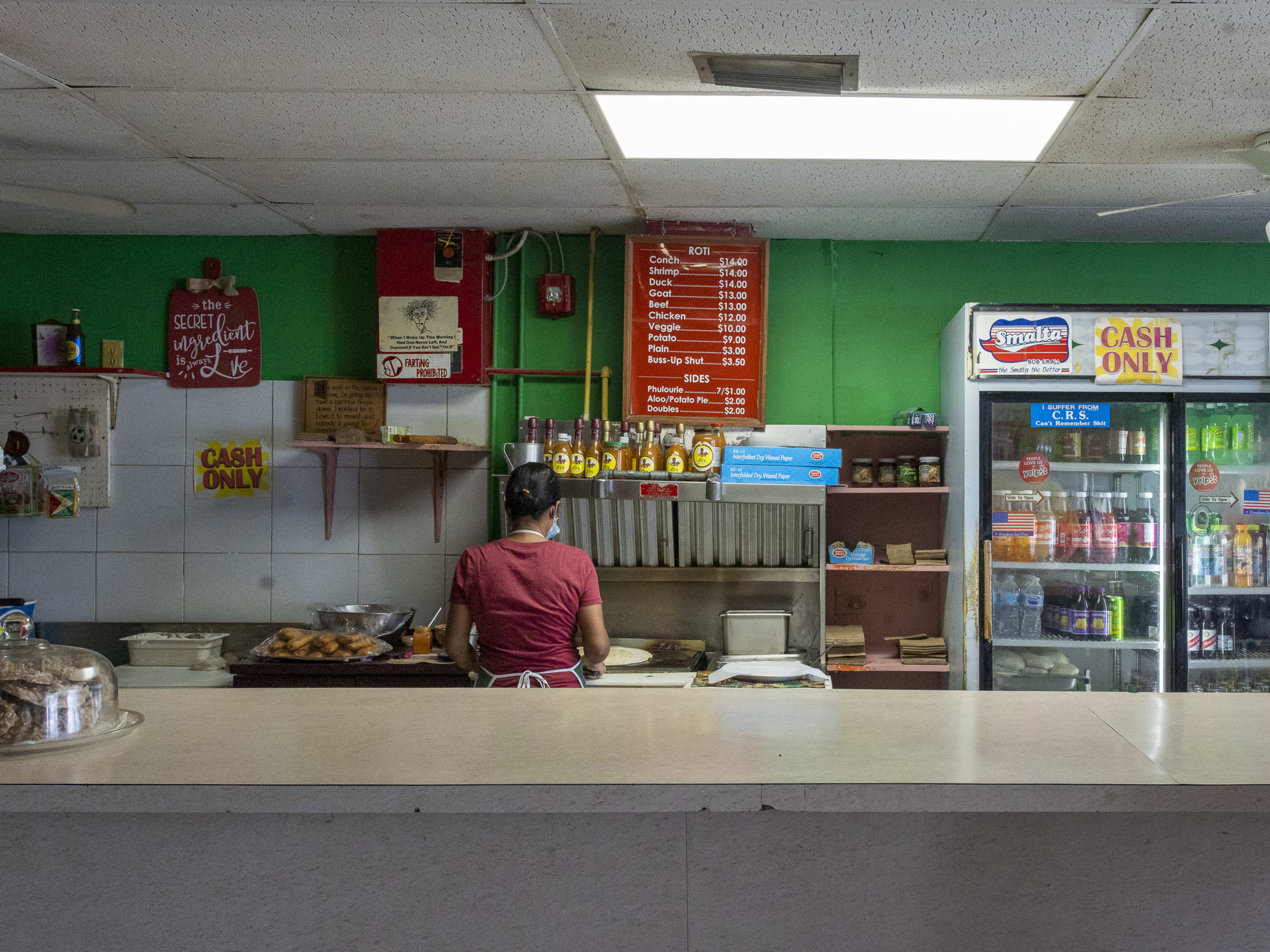 A counter with a chef cooking behind it.