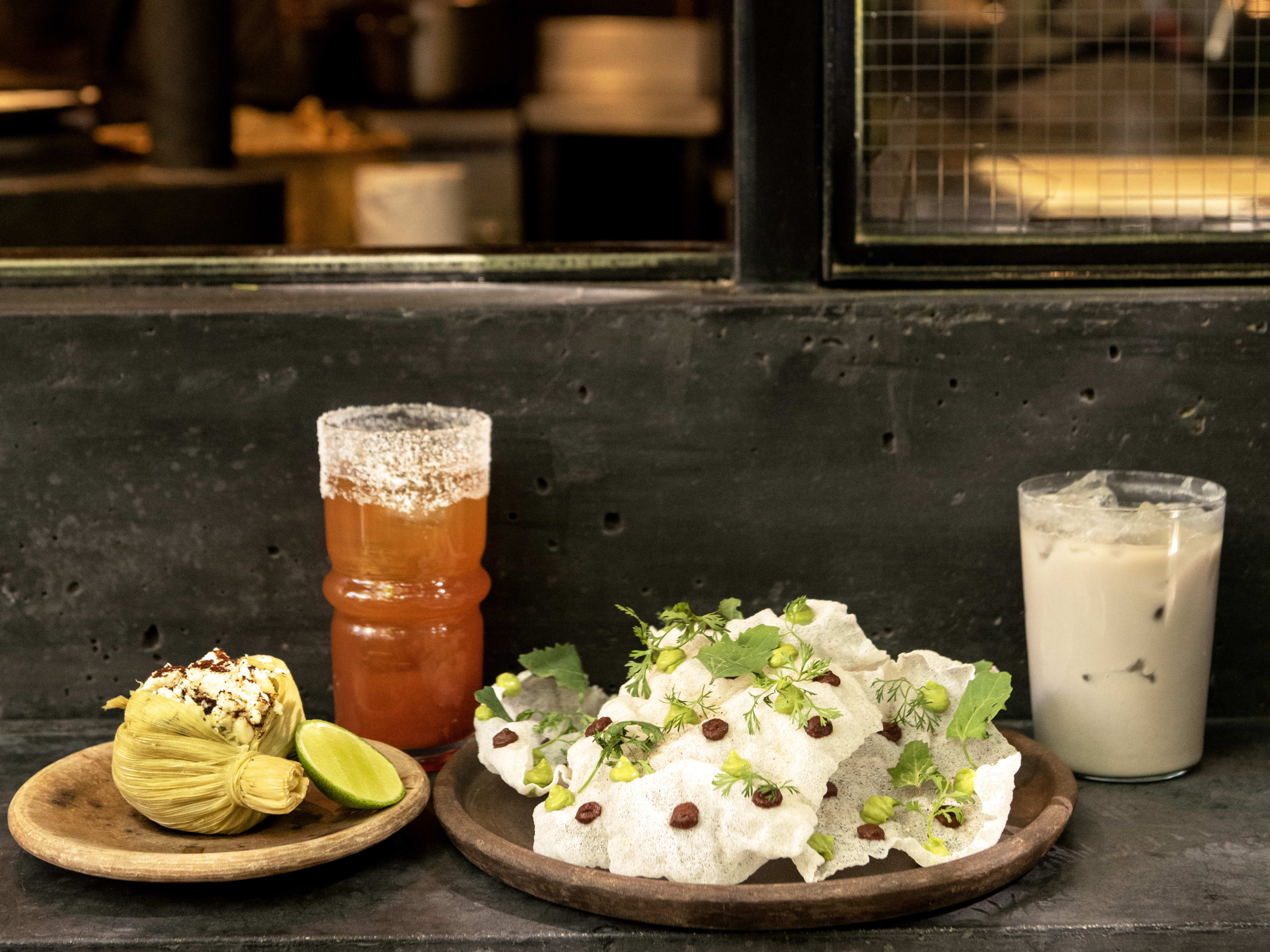 Spread of food at cocktails on outdoor window bar at Ticuchi