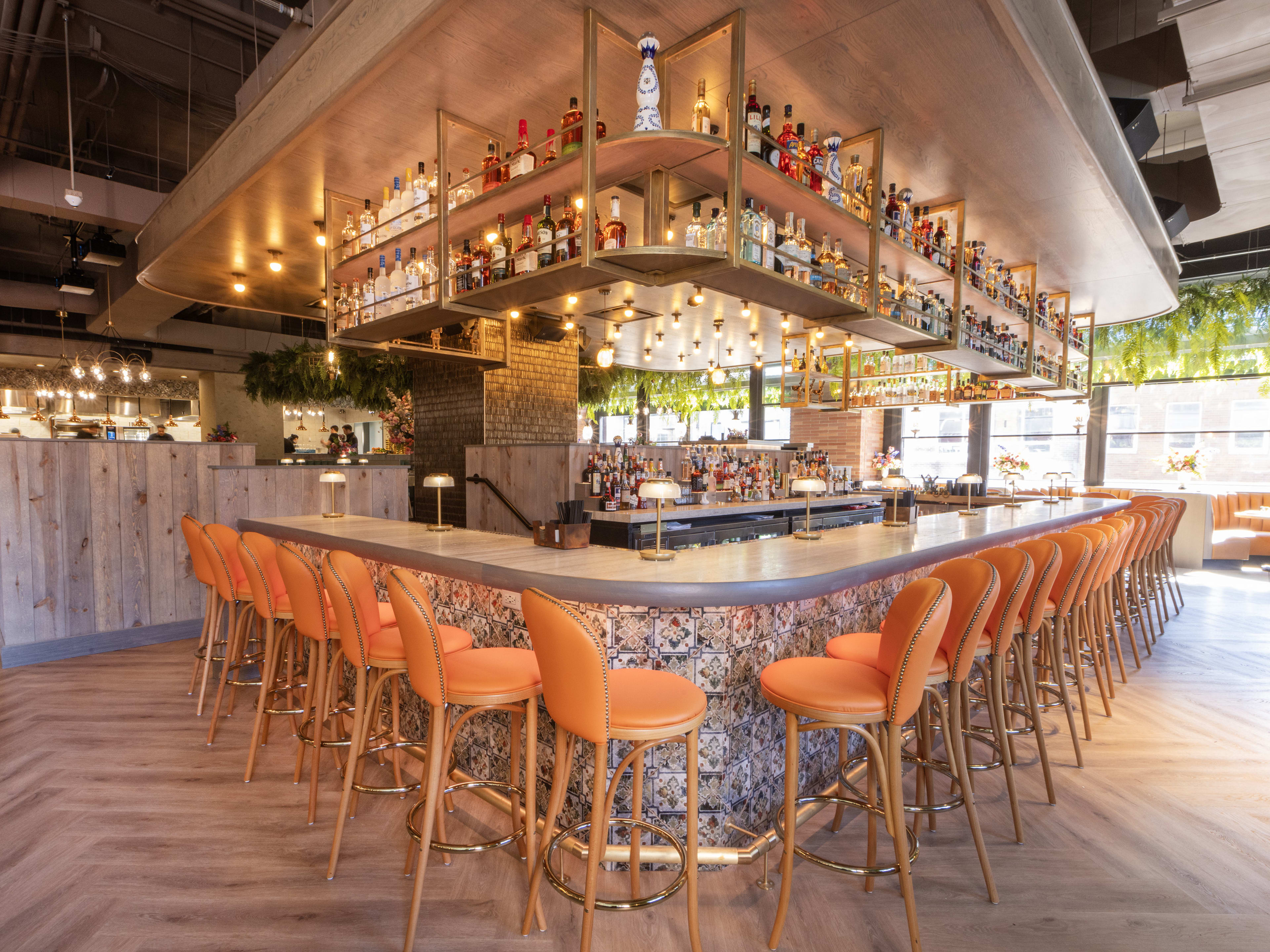 A long bar with plenty of stools in a bright dining room.