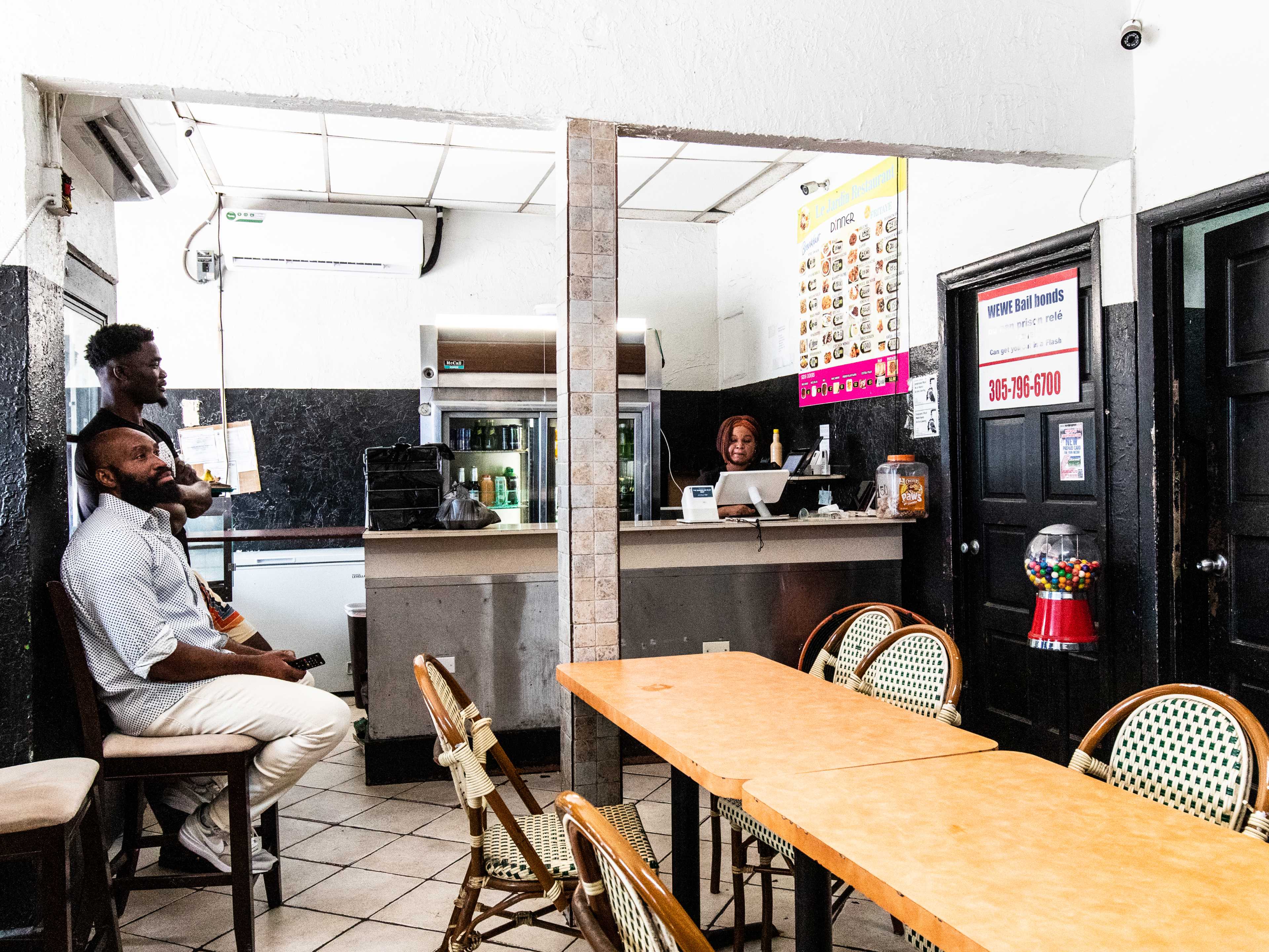 Two men wait for their food inside a small restaurant.