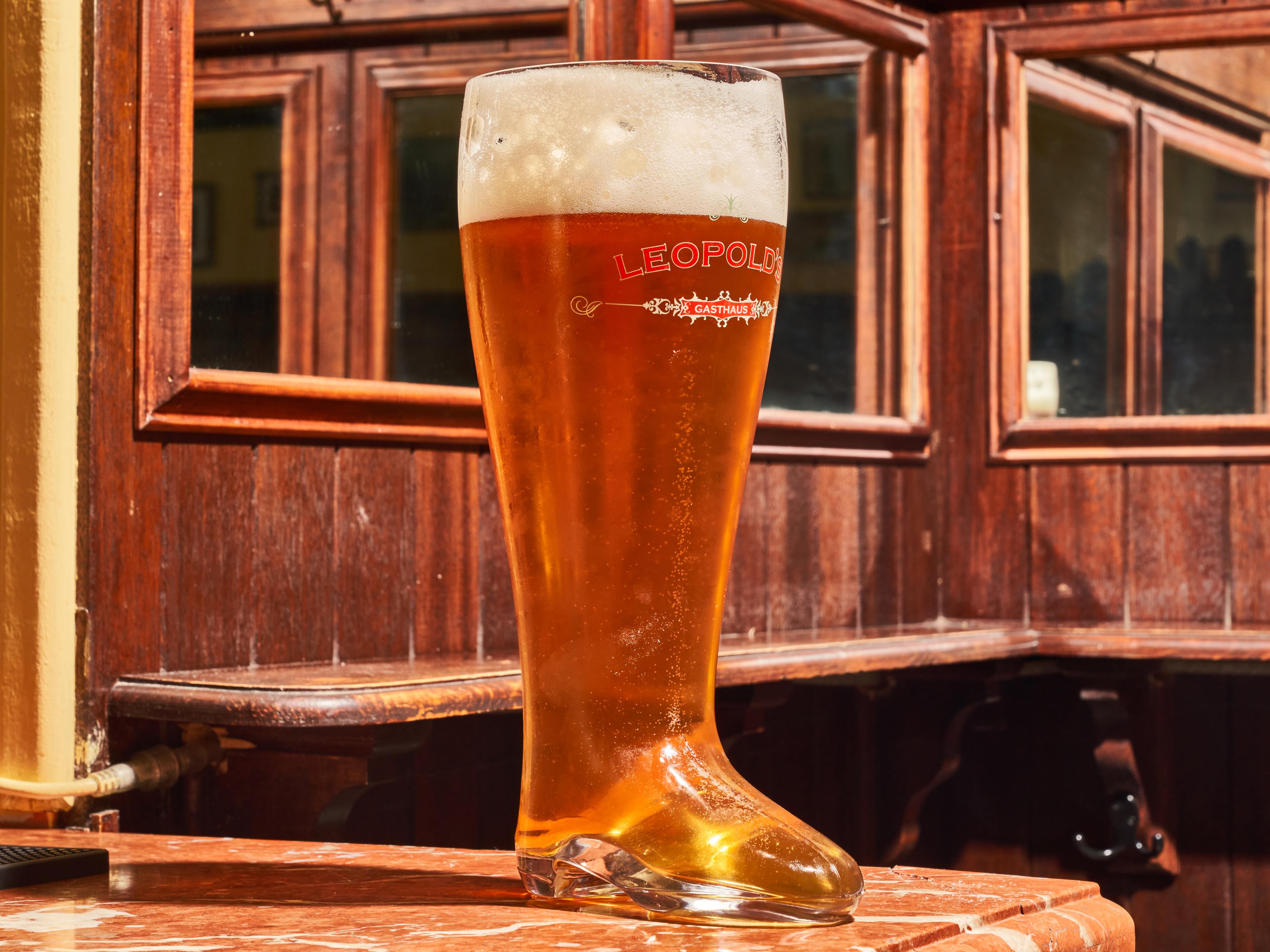 massive glass boot filled with beer in bar that looks like cabin