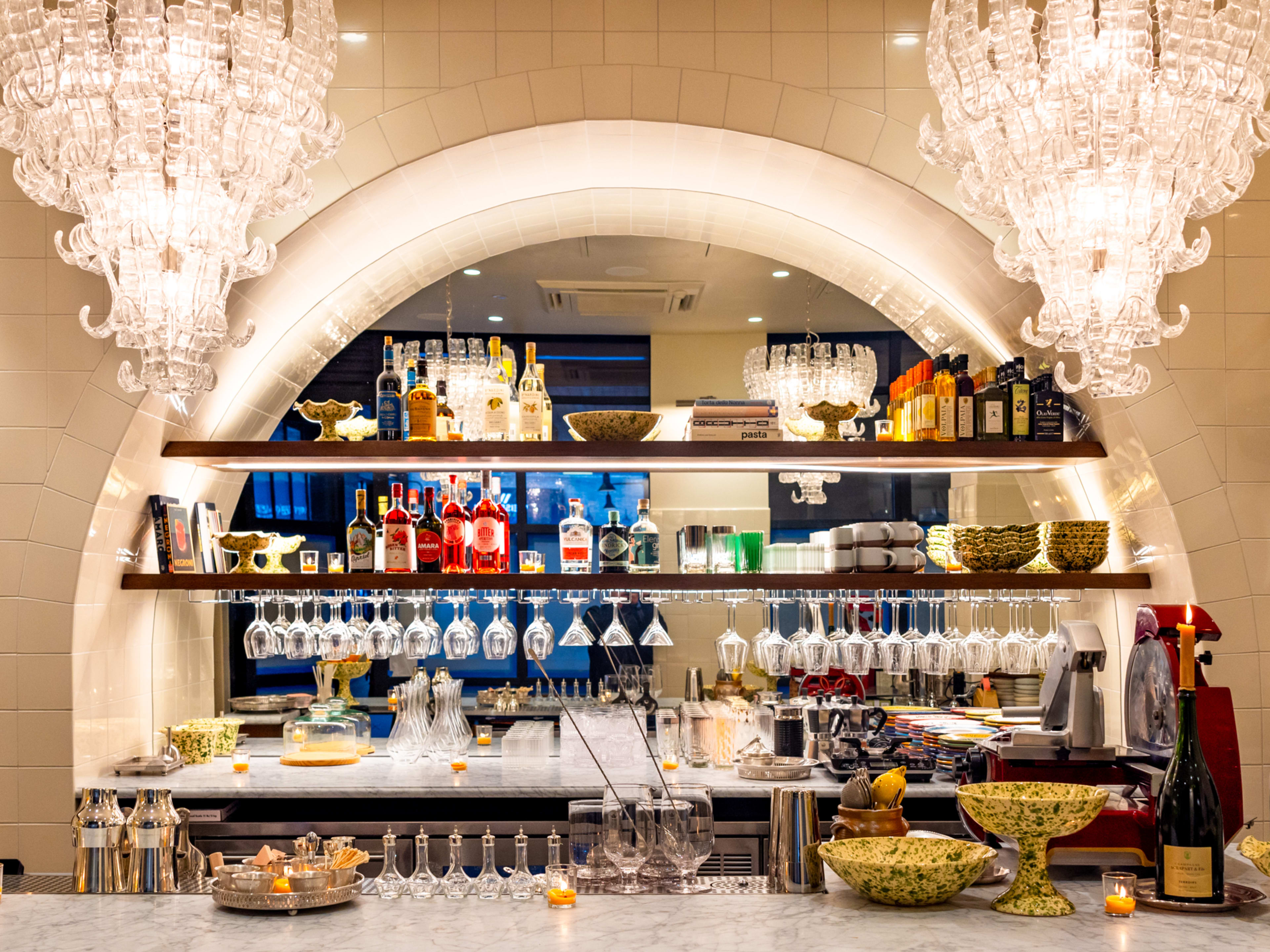 standing marble bar with crystal chandeliers hanging above