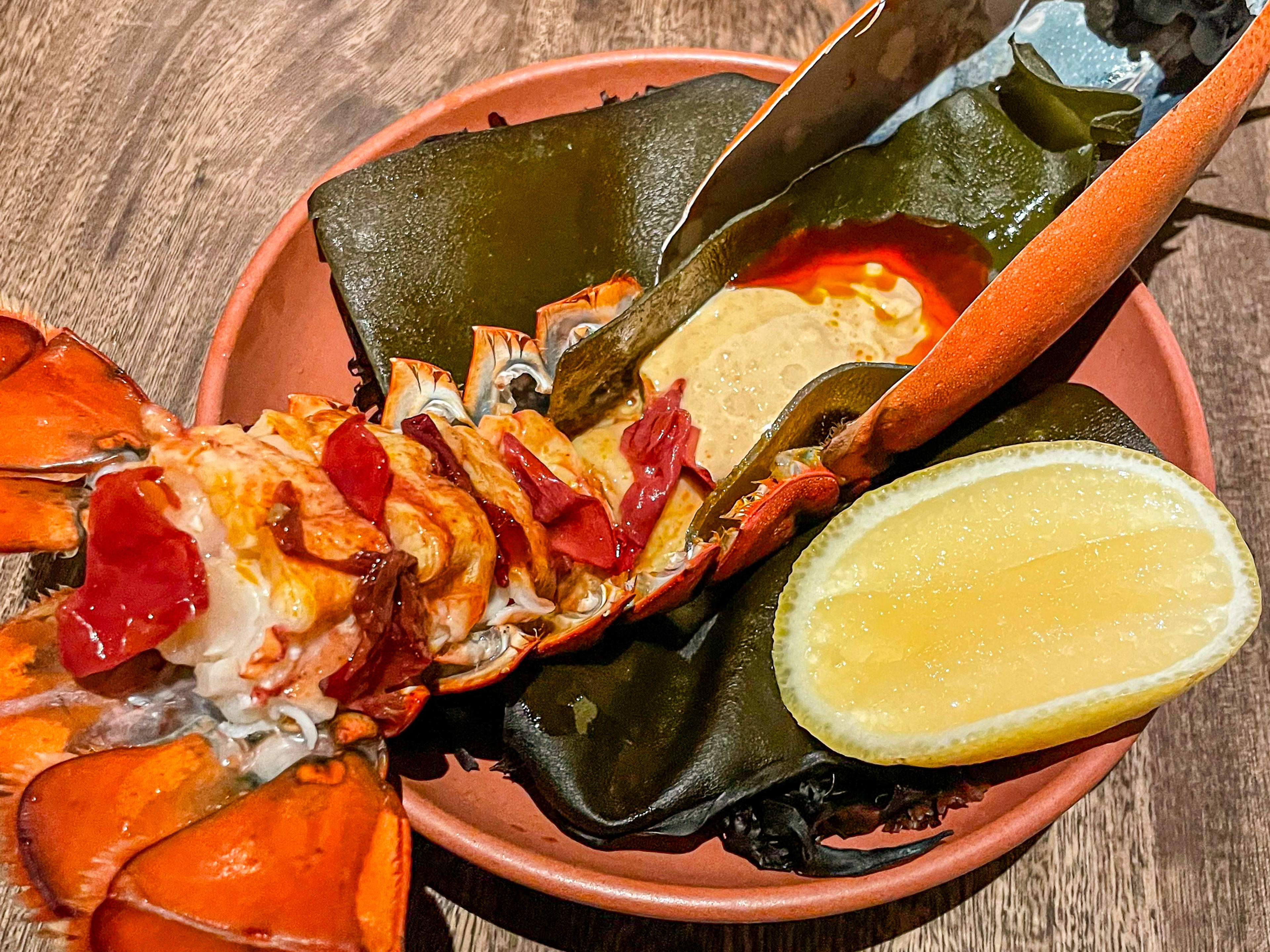 Lobster served in-shell with aioli and a lemon wedge.