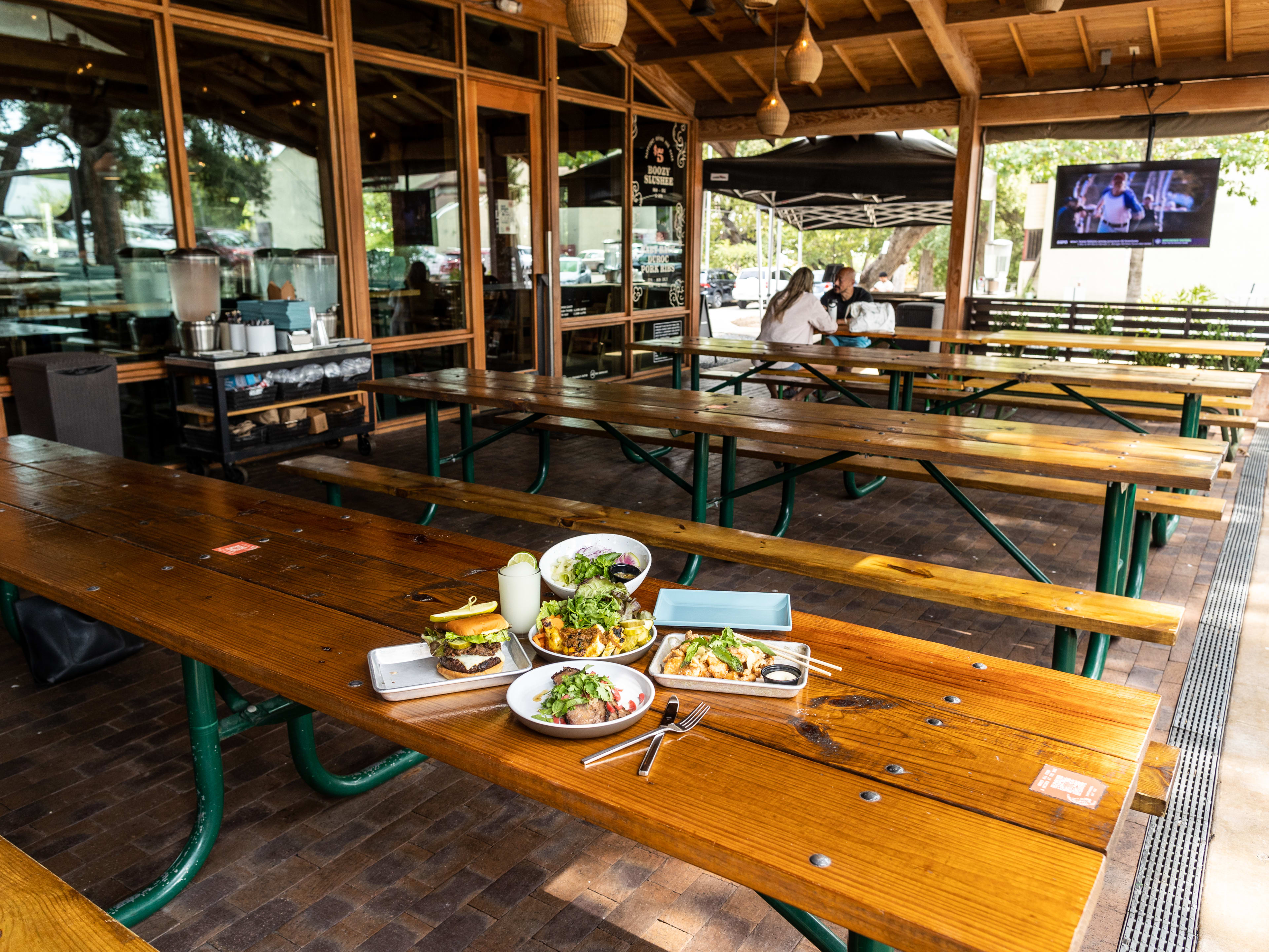 A spread of dishes on a large picnic table on the patio at Loro.