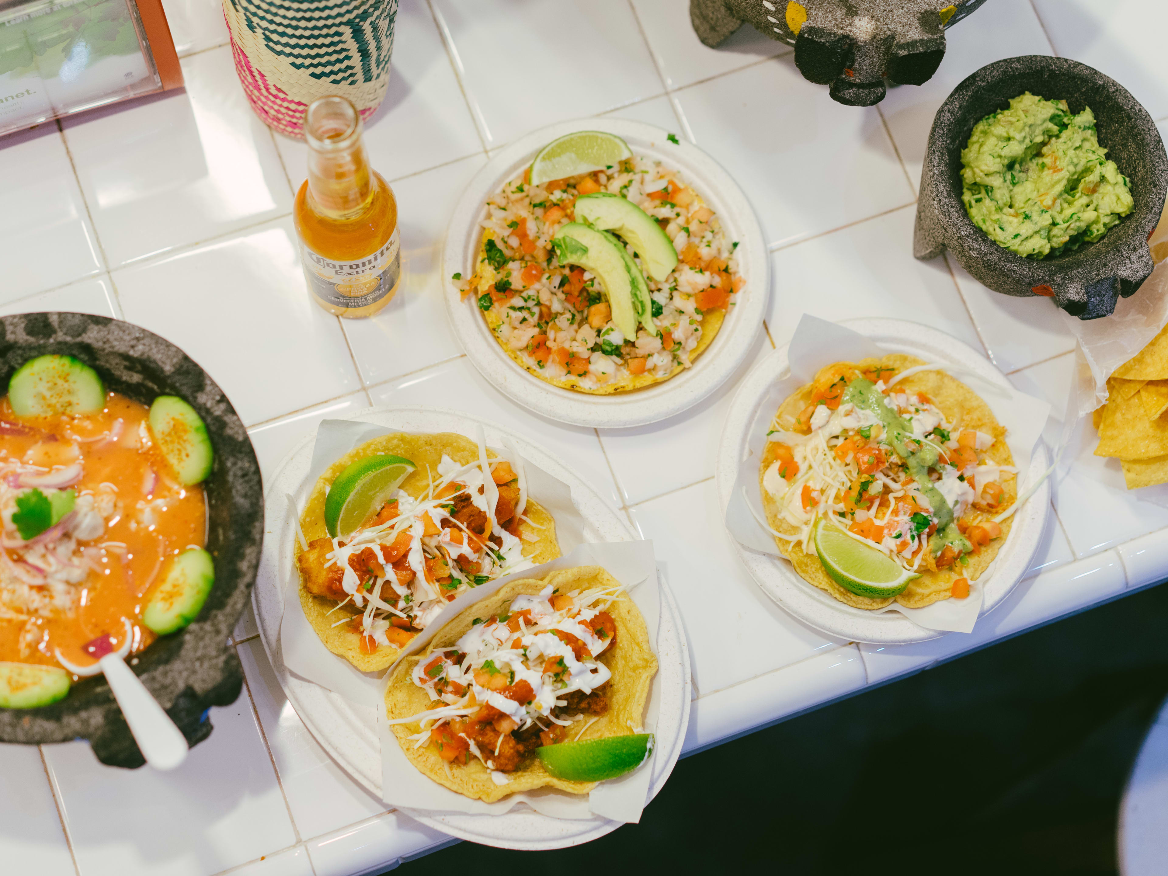 A spread of seafood tacos and tostadas, with a big serving of aguachile to the side.