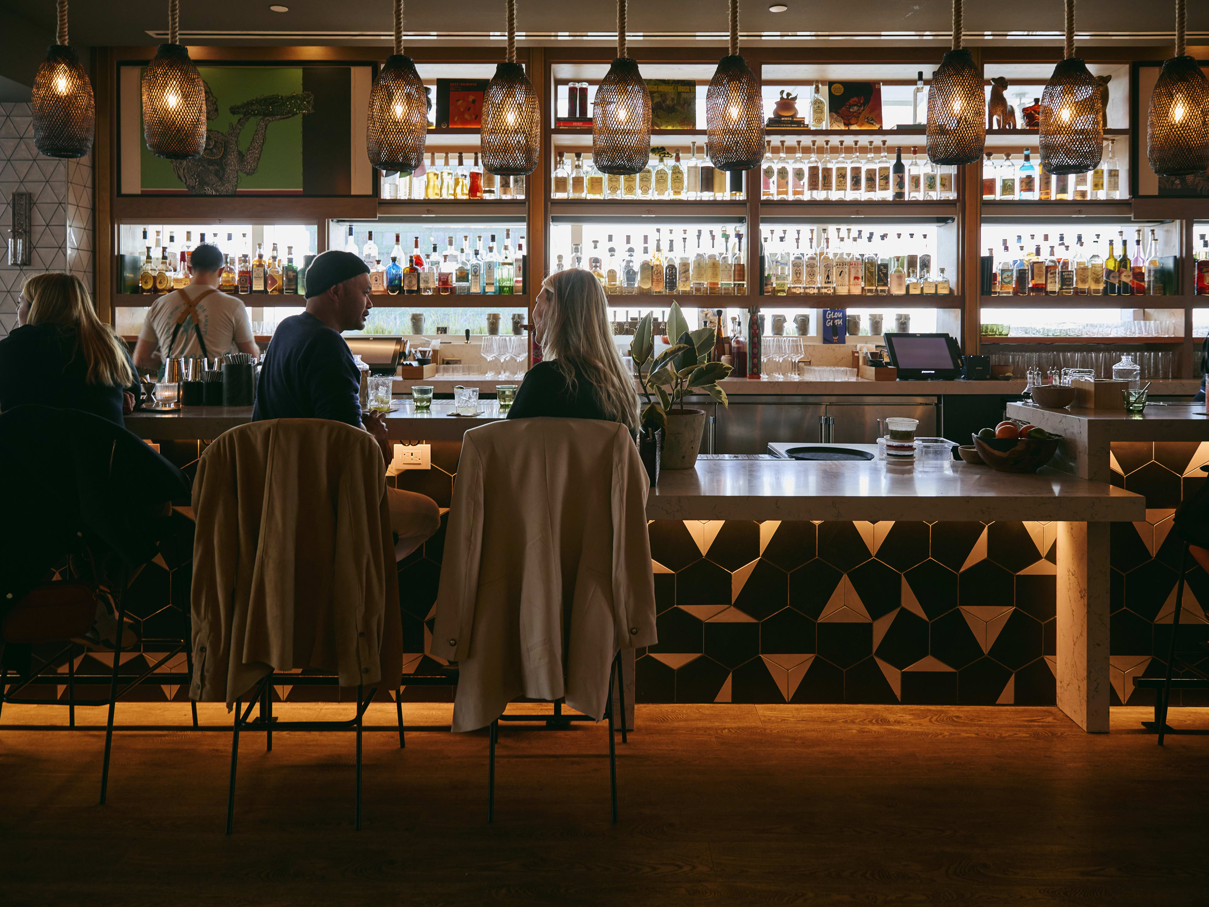 A few people sitting at the bar at Cavaña San Francisco.