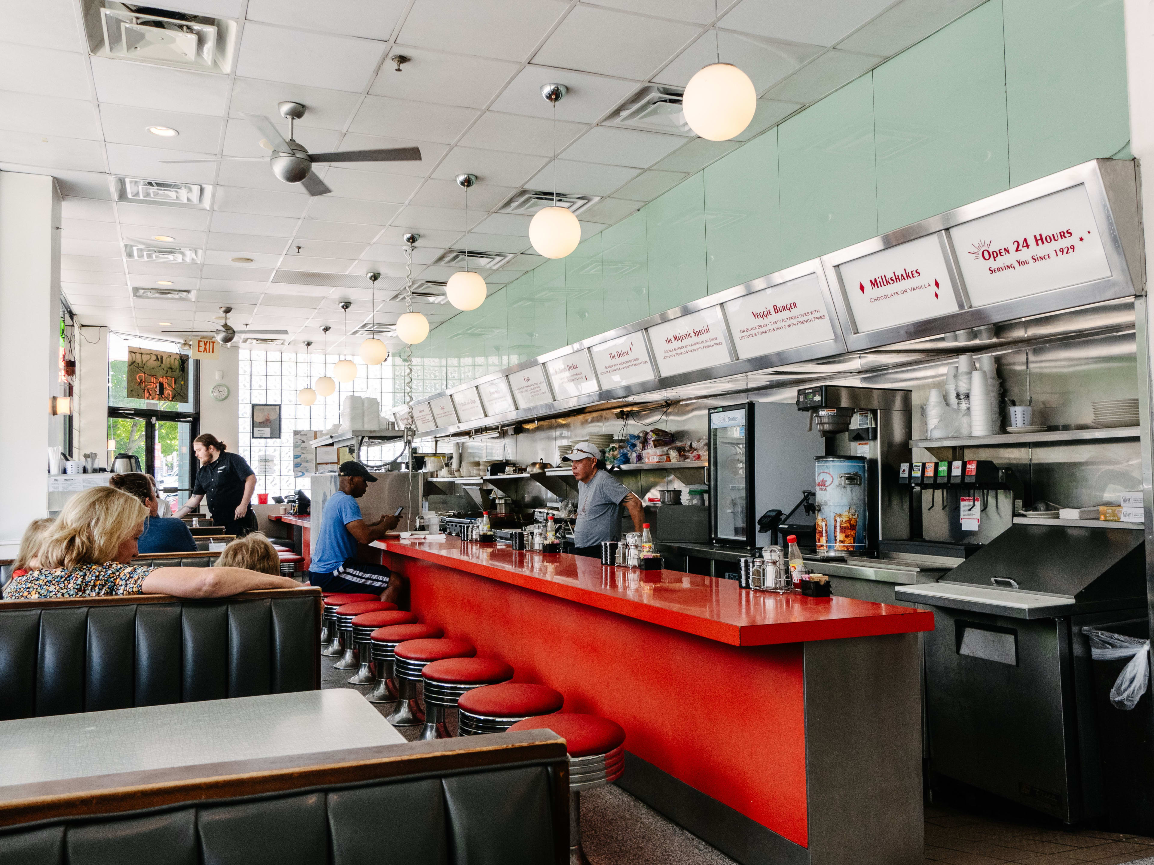 Red stools at a counter and booths along one wall.