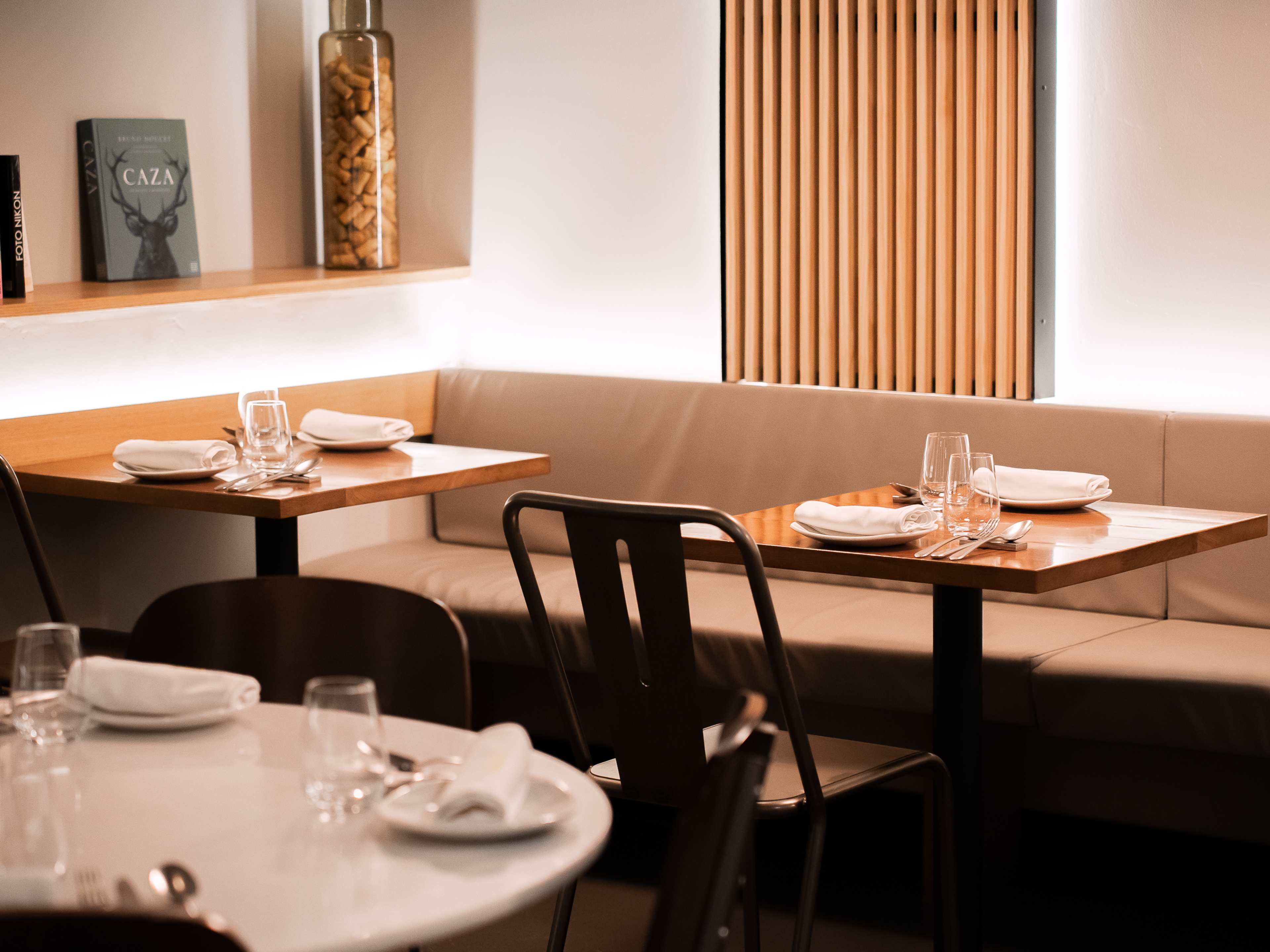 Interior dining space of Maleducat with set tables and glowing lights