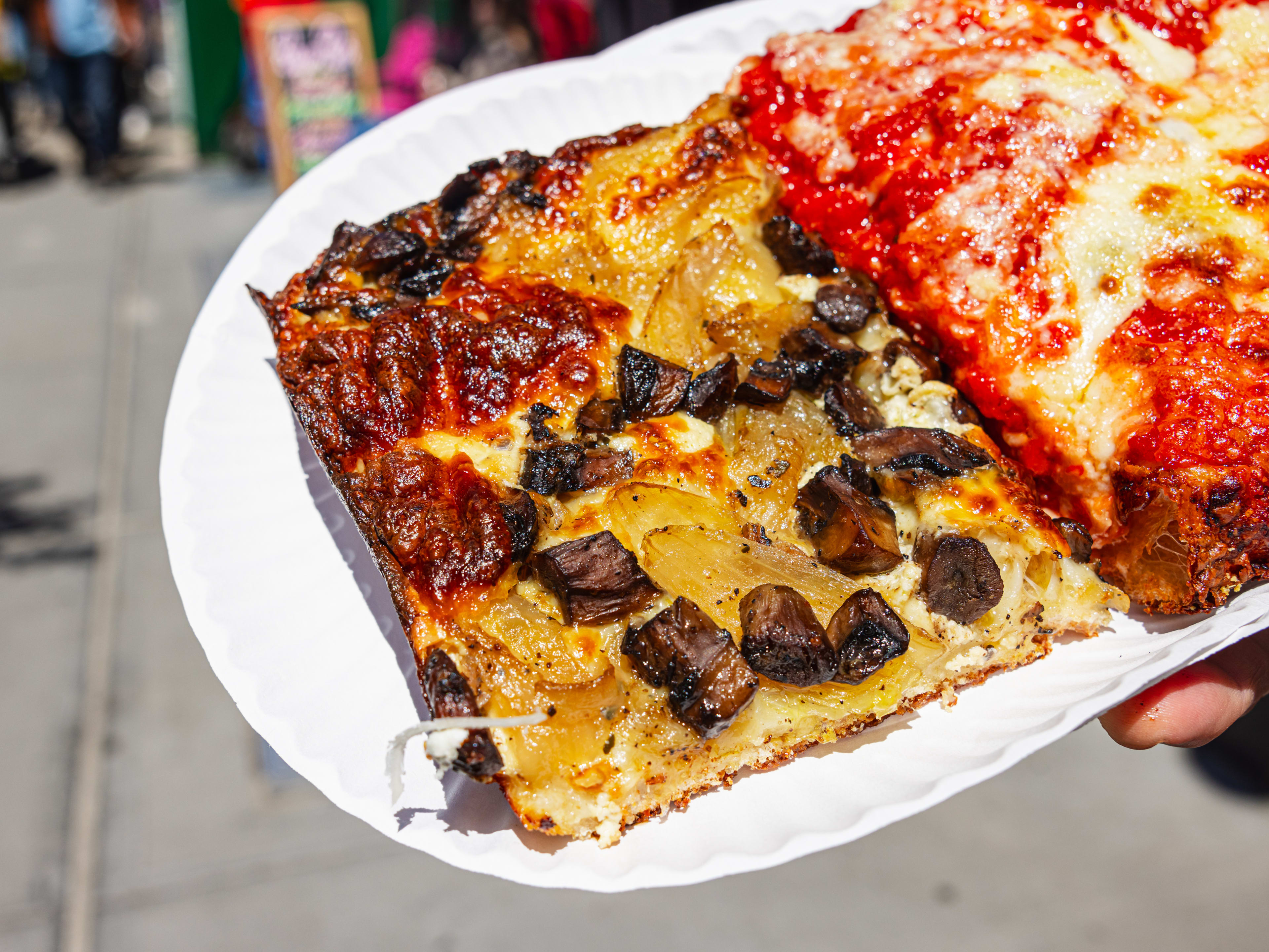 a square slice of pizza with mushrooms, ricotta, and caramelized onions