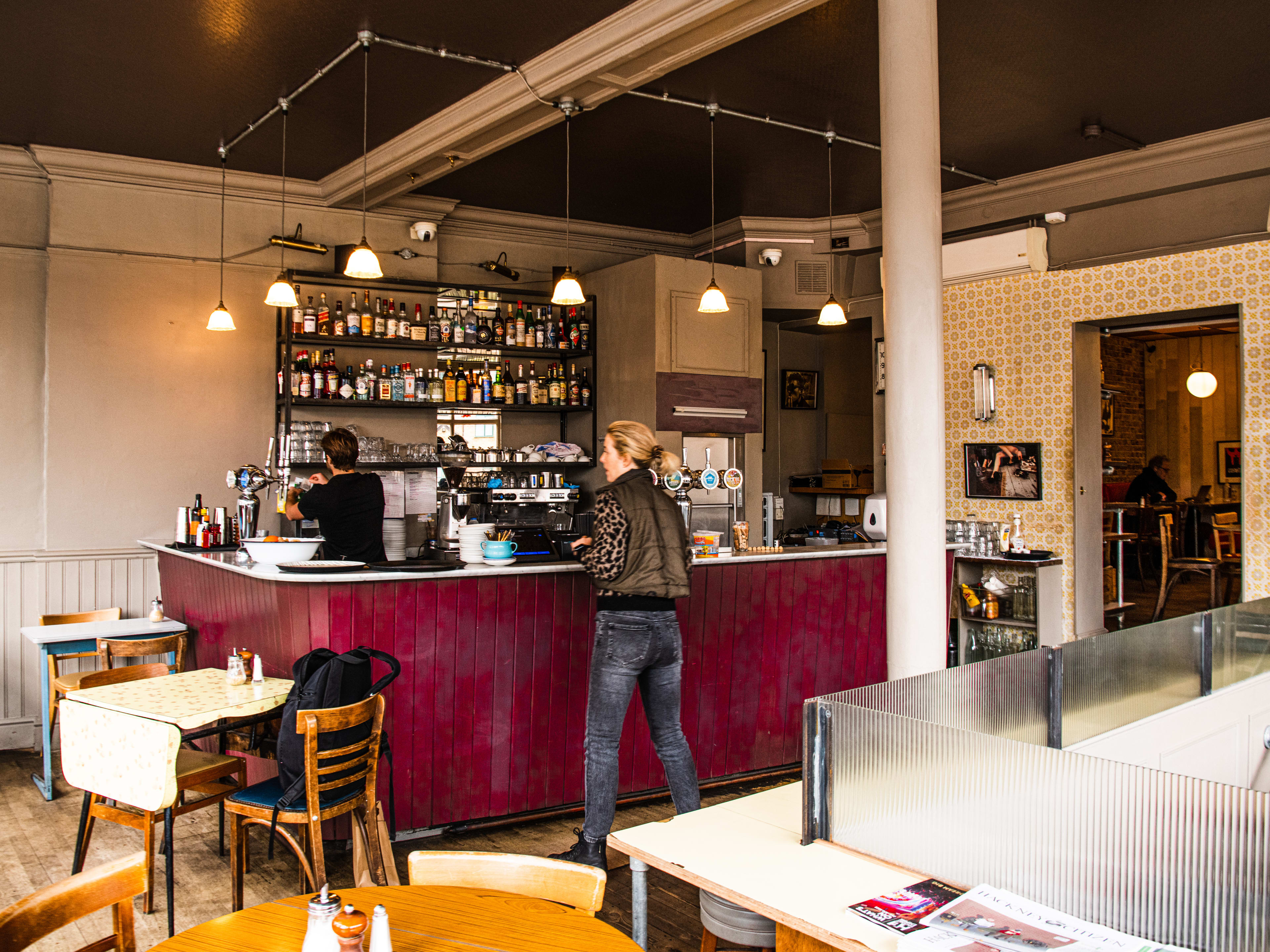 A person waits for their order at the red coffee counter at Market Cafe.