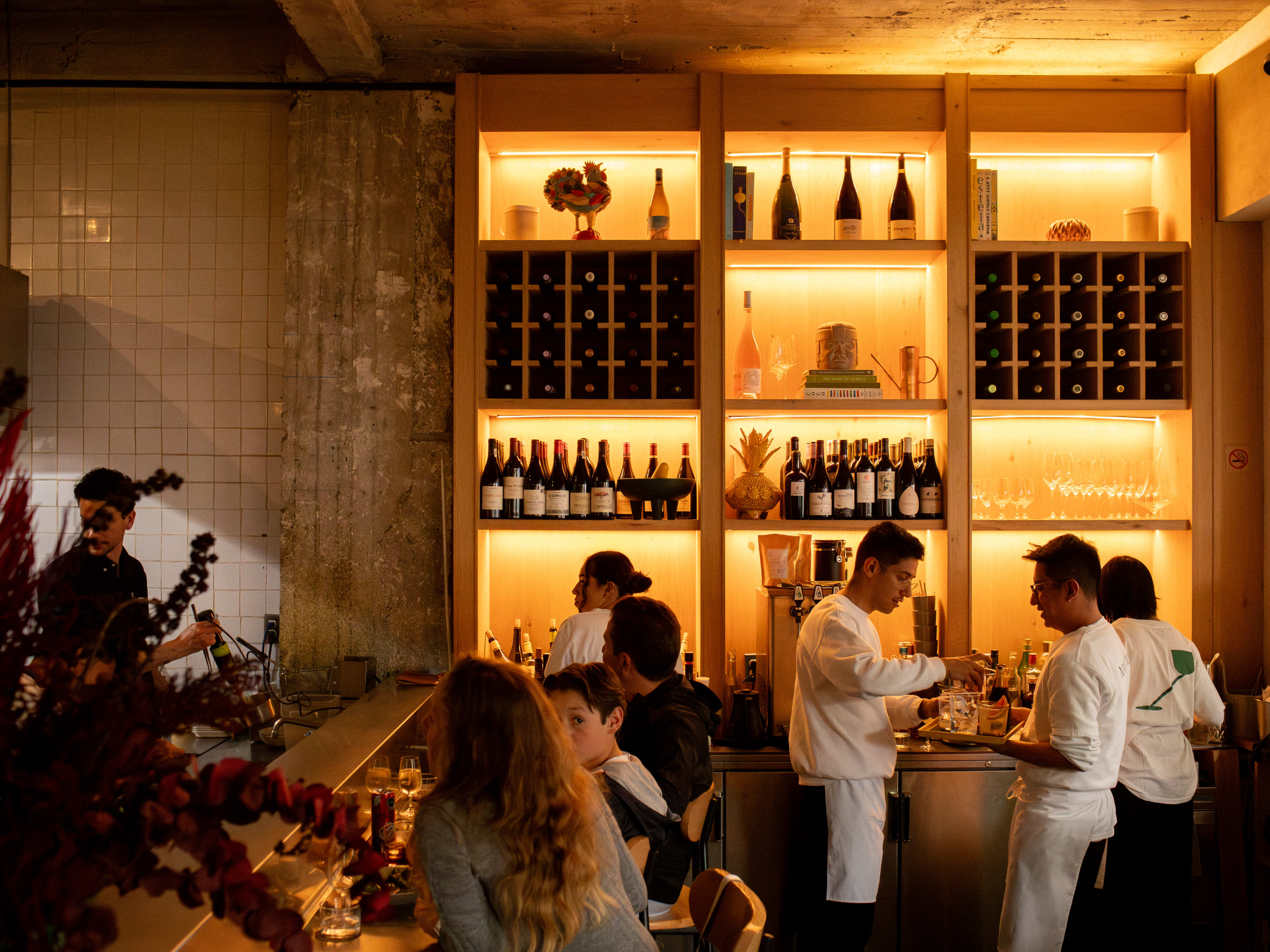 A dramatically lit bar and a room full of people at Martinez, a restaurant in Mexico City