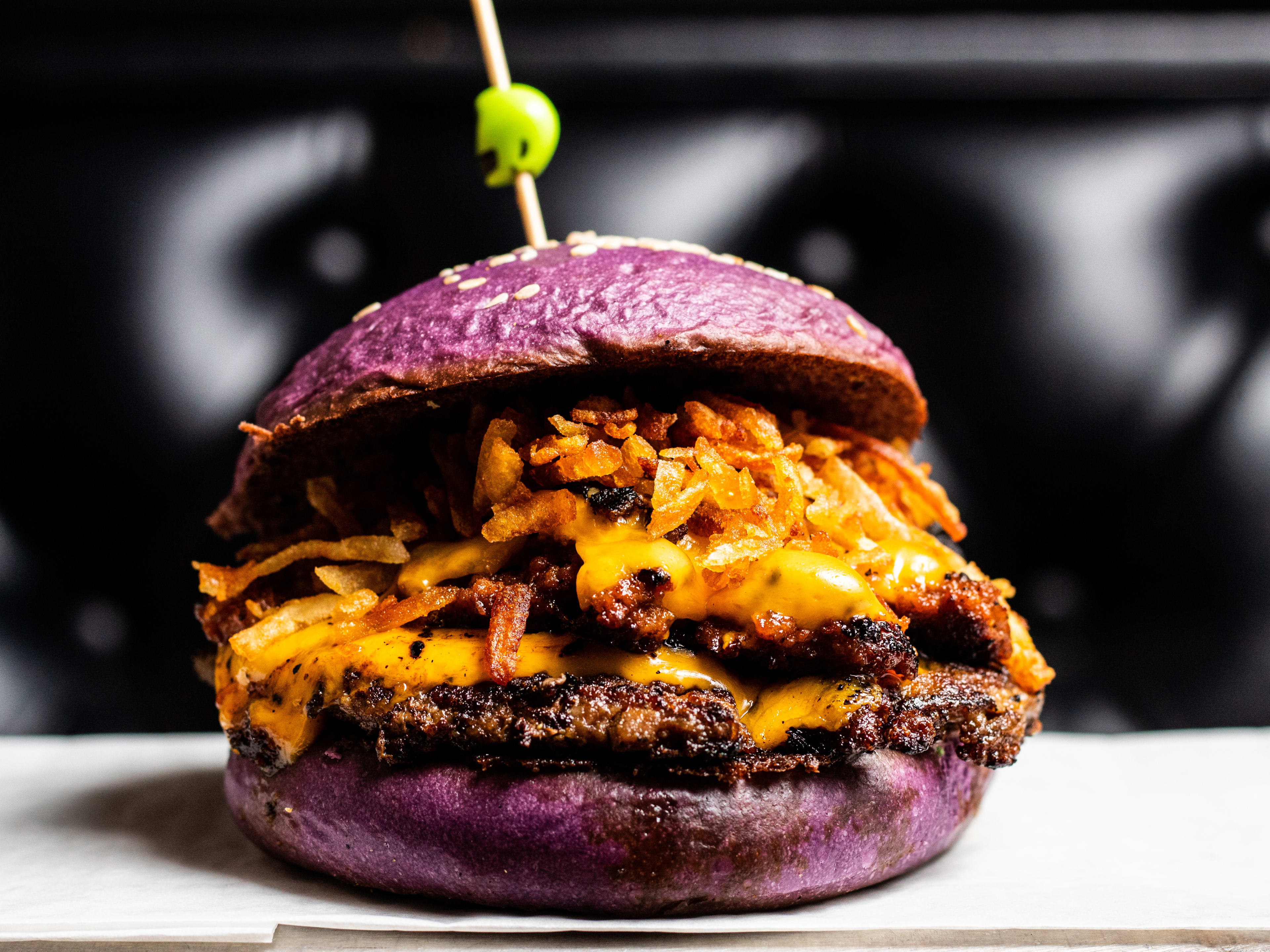 A burger with a purple bun.