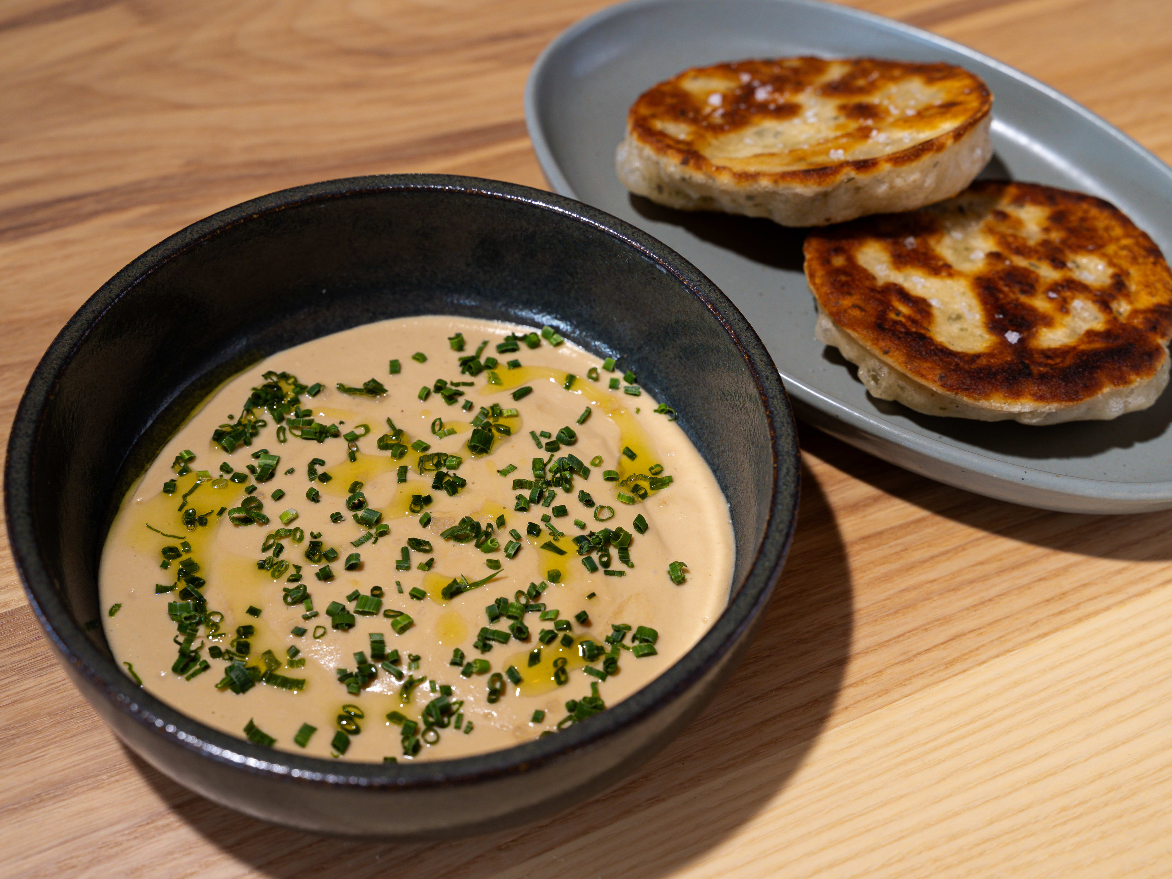 A bowl of French onion dip and a plate with two scallion pancakes.