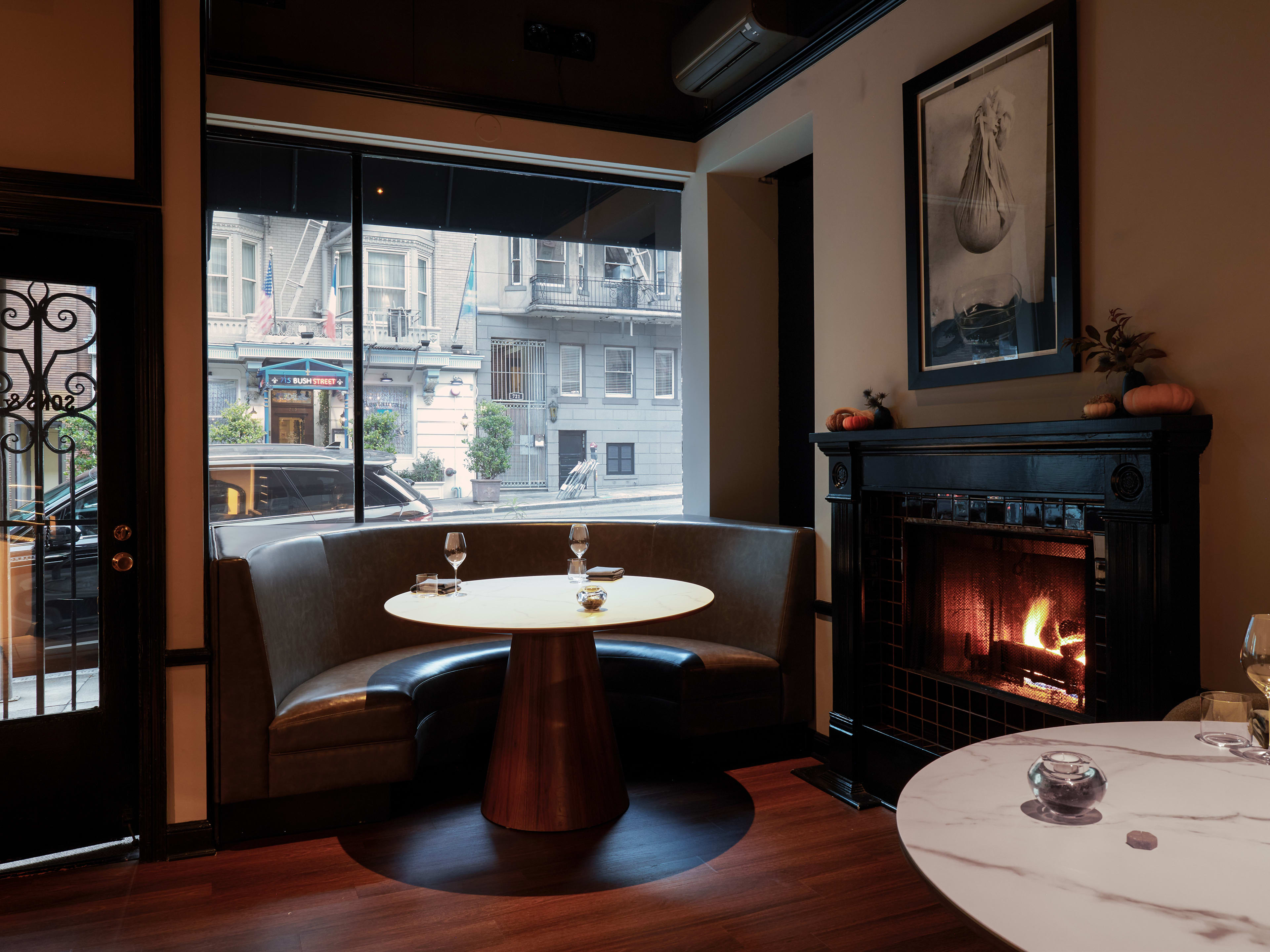 dark and cozy window booth next to a blazing fireplace