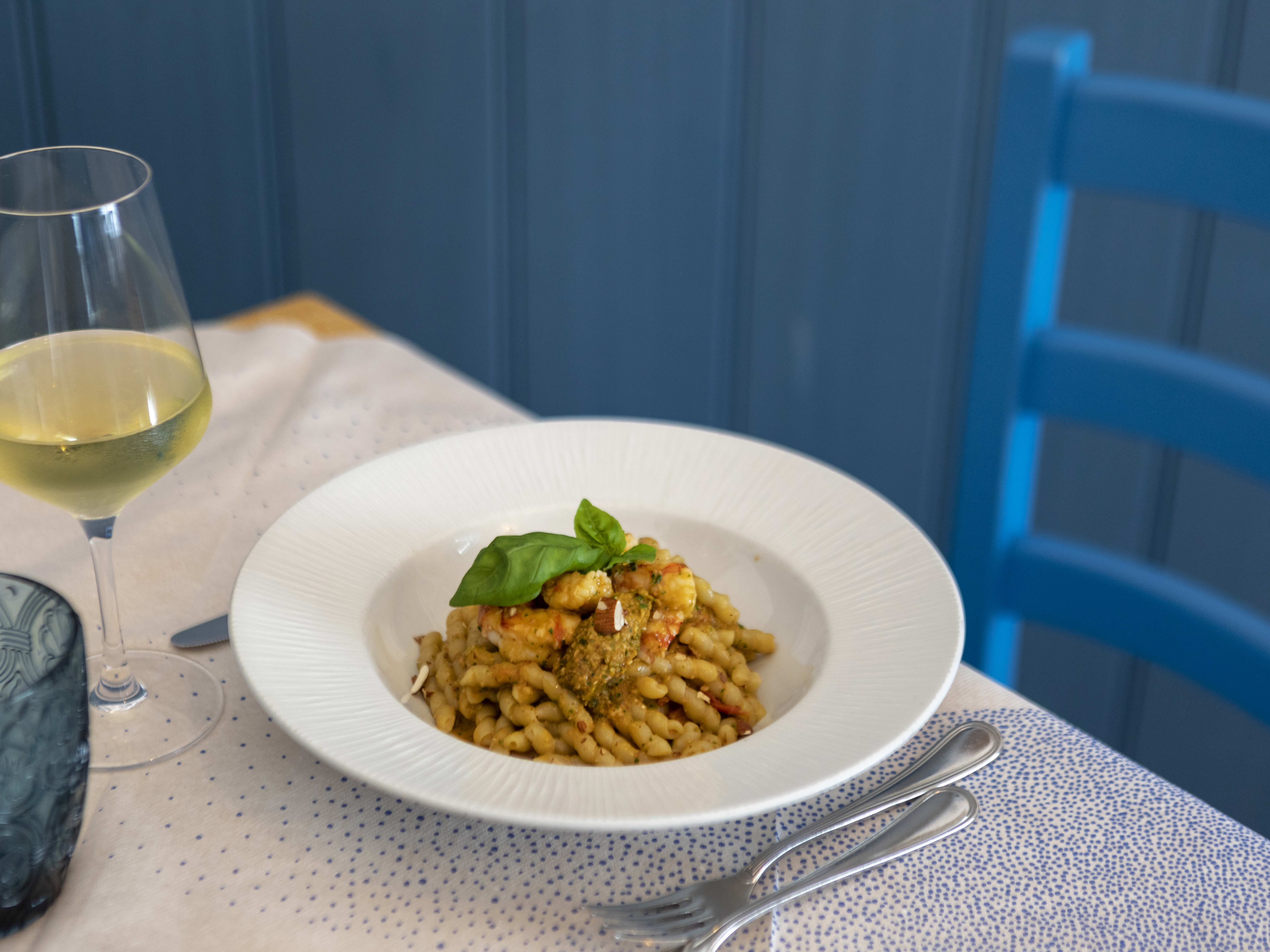 Bowl of lobster pasta along with glass of white wine at Osteria Mercede