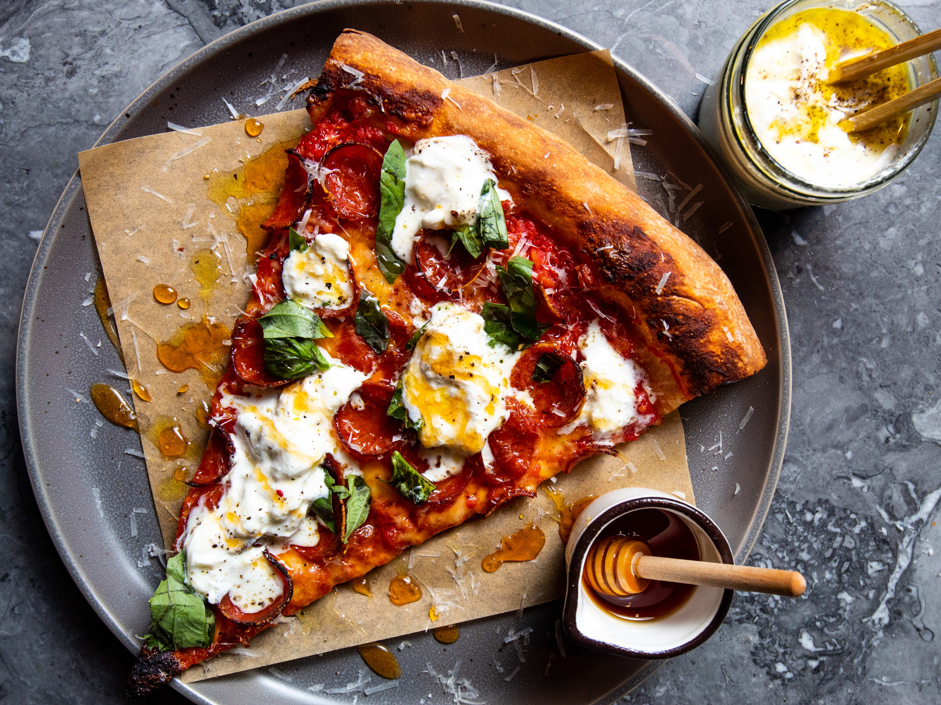 pepperoni pizza with small jar of honey for drizzling