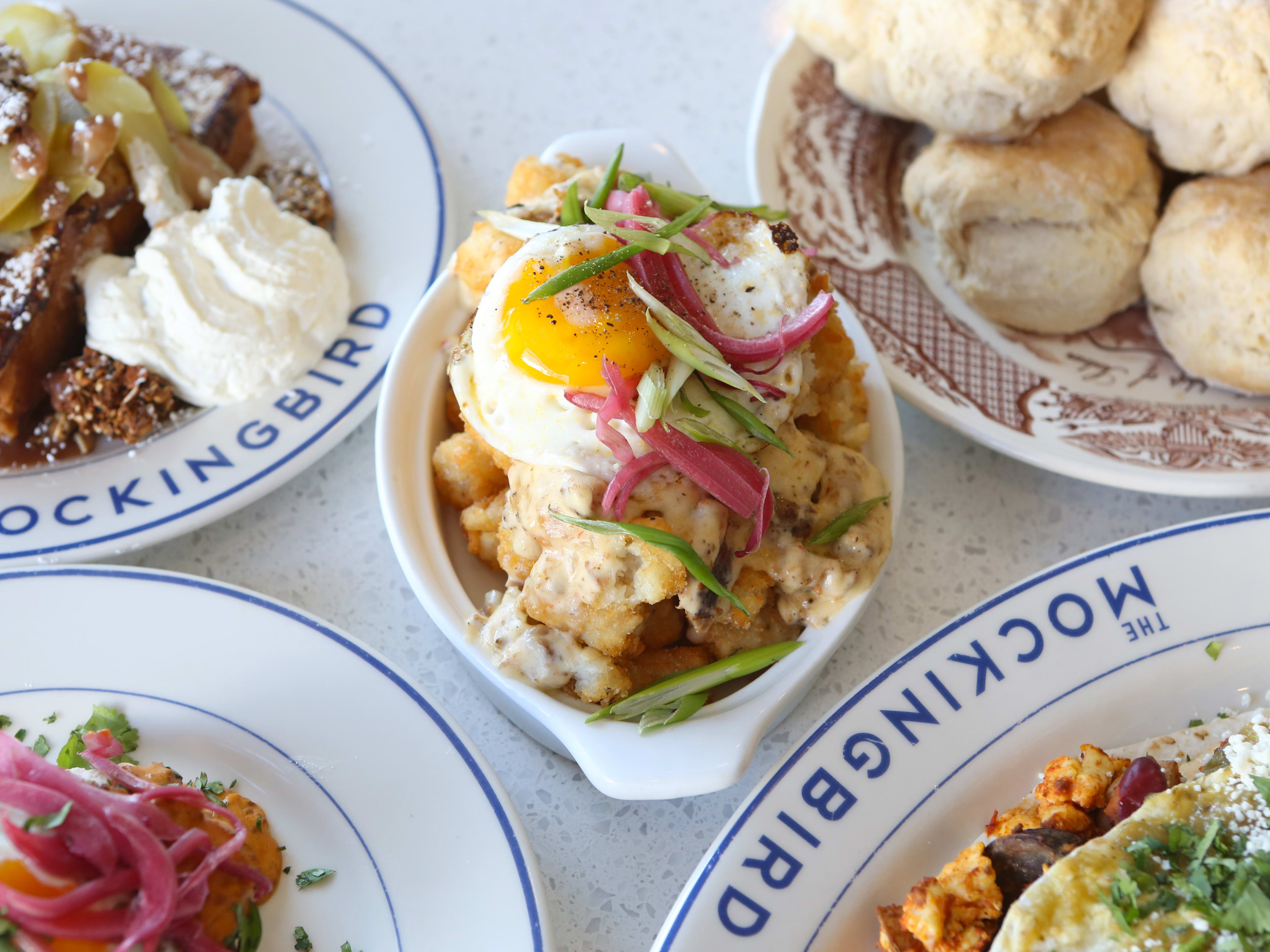 Plates of eggs, french toast, and biscuits on a table at The Mockingbird in Nashville