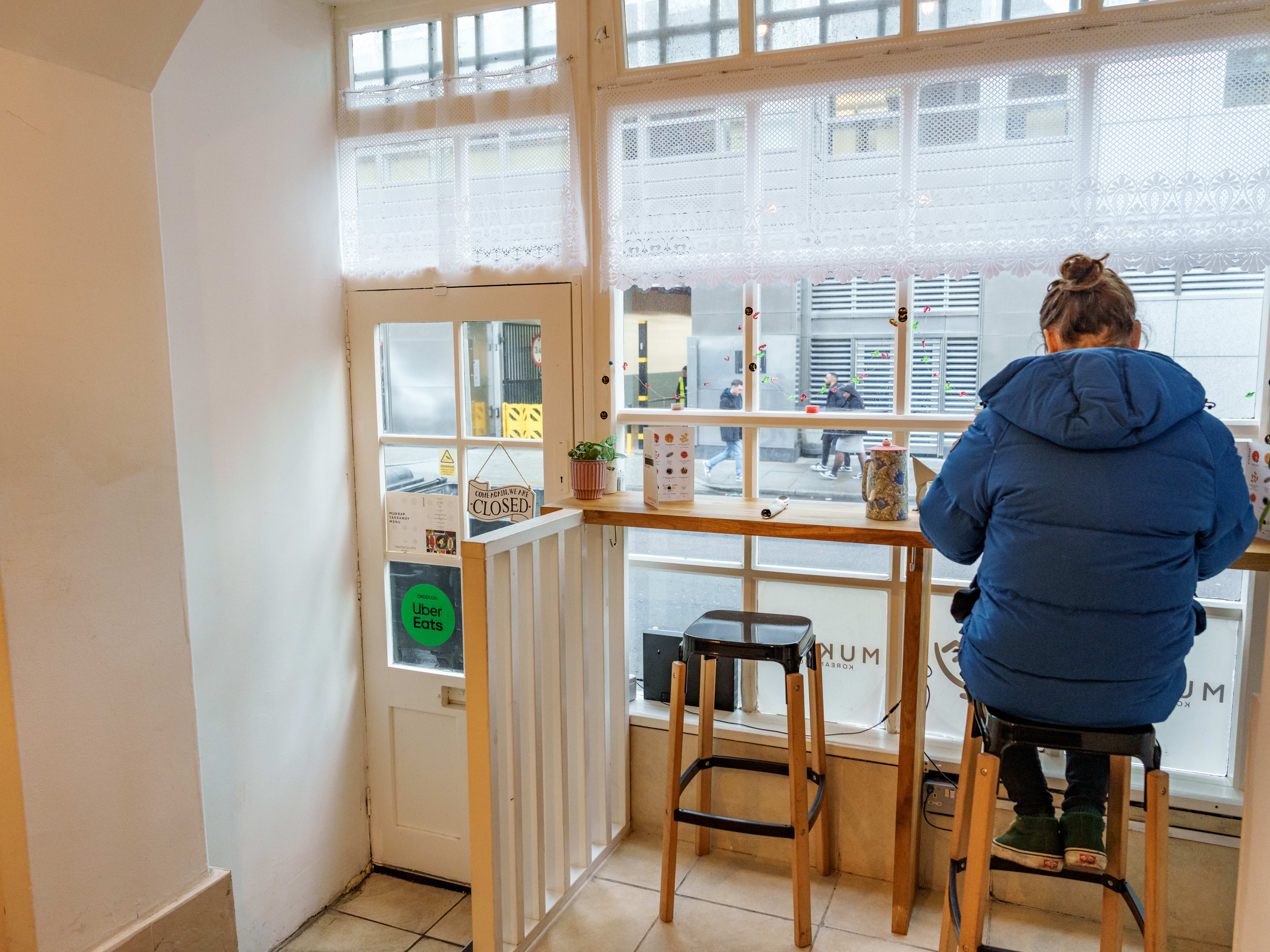 interior of mukbap facing front door and window, where a person sits at the two person counter