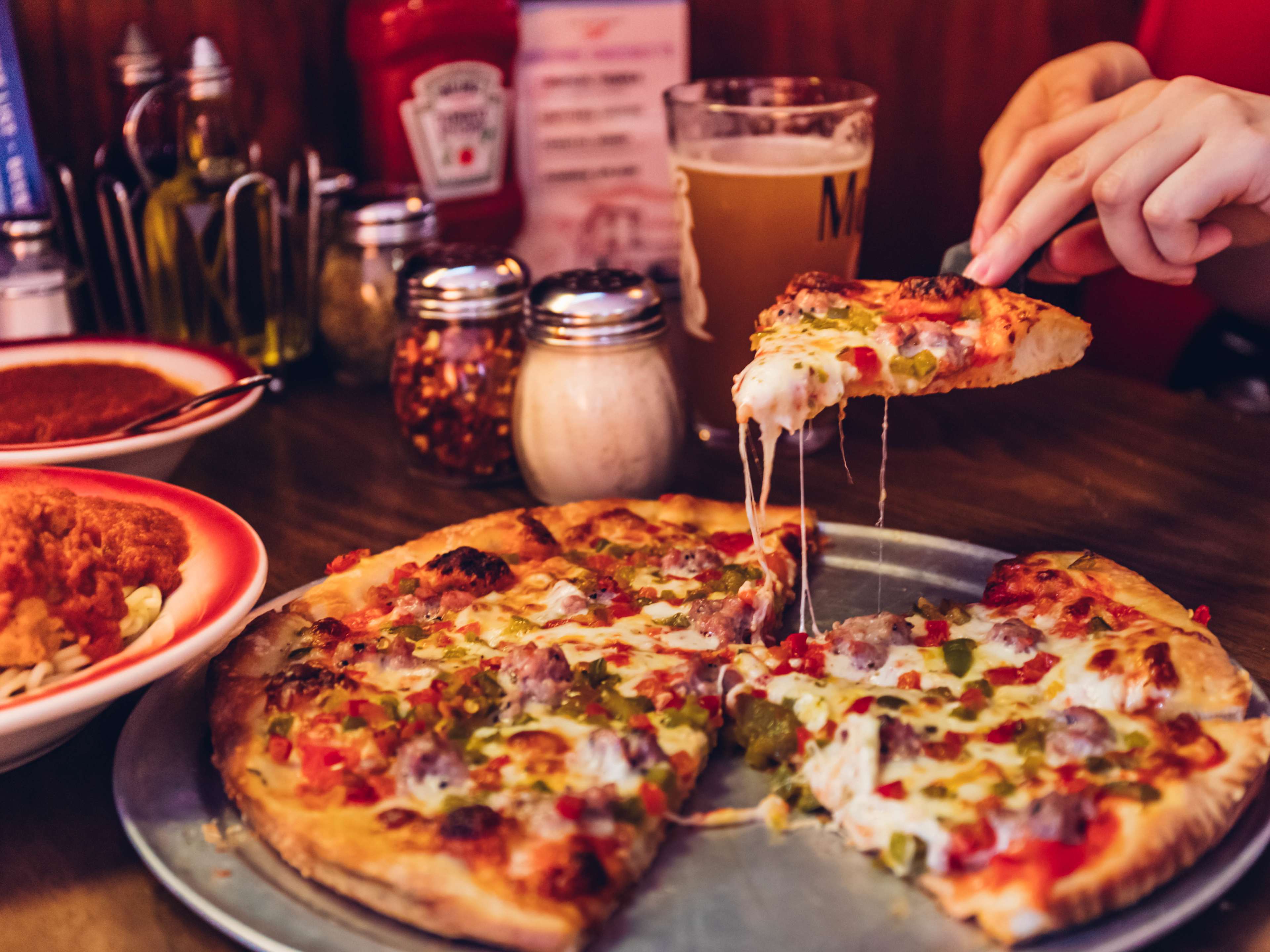 A pizza being served in a diner-like booth.