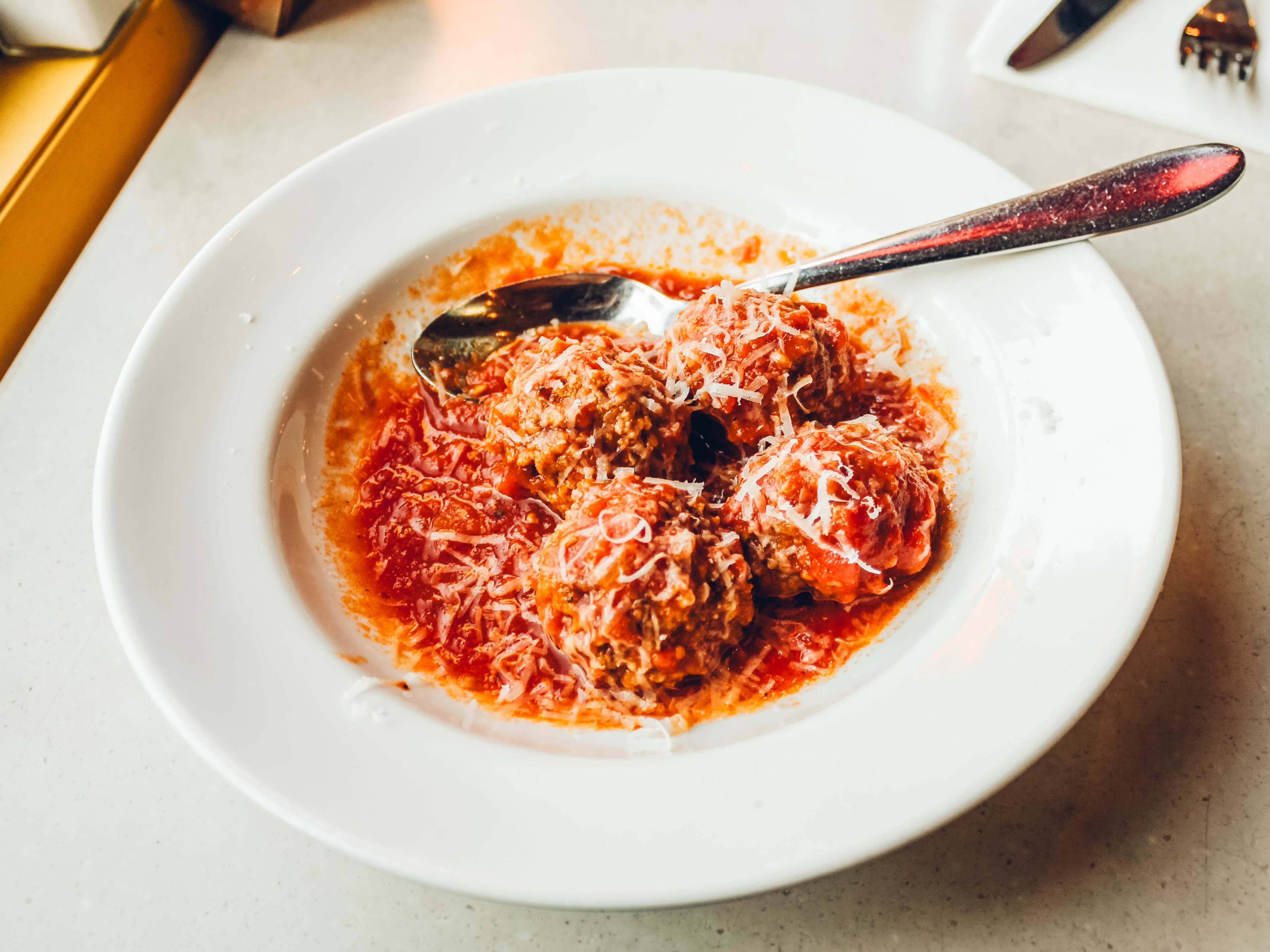 A bowl of meatballs covered in red sauce.