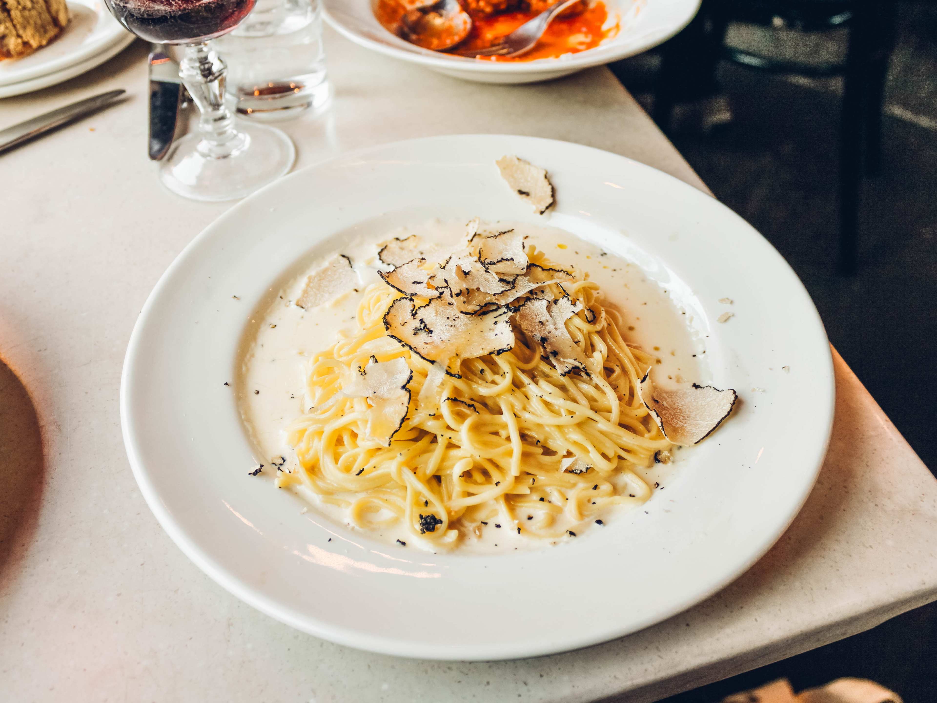 A bowl of pasta topped with shaved truffles.