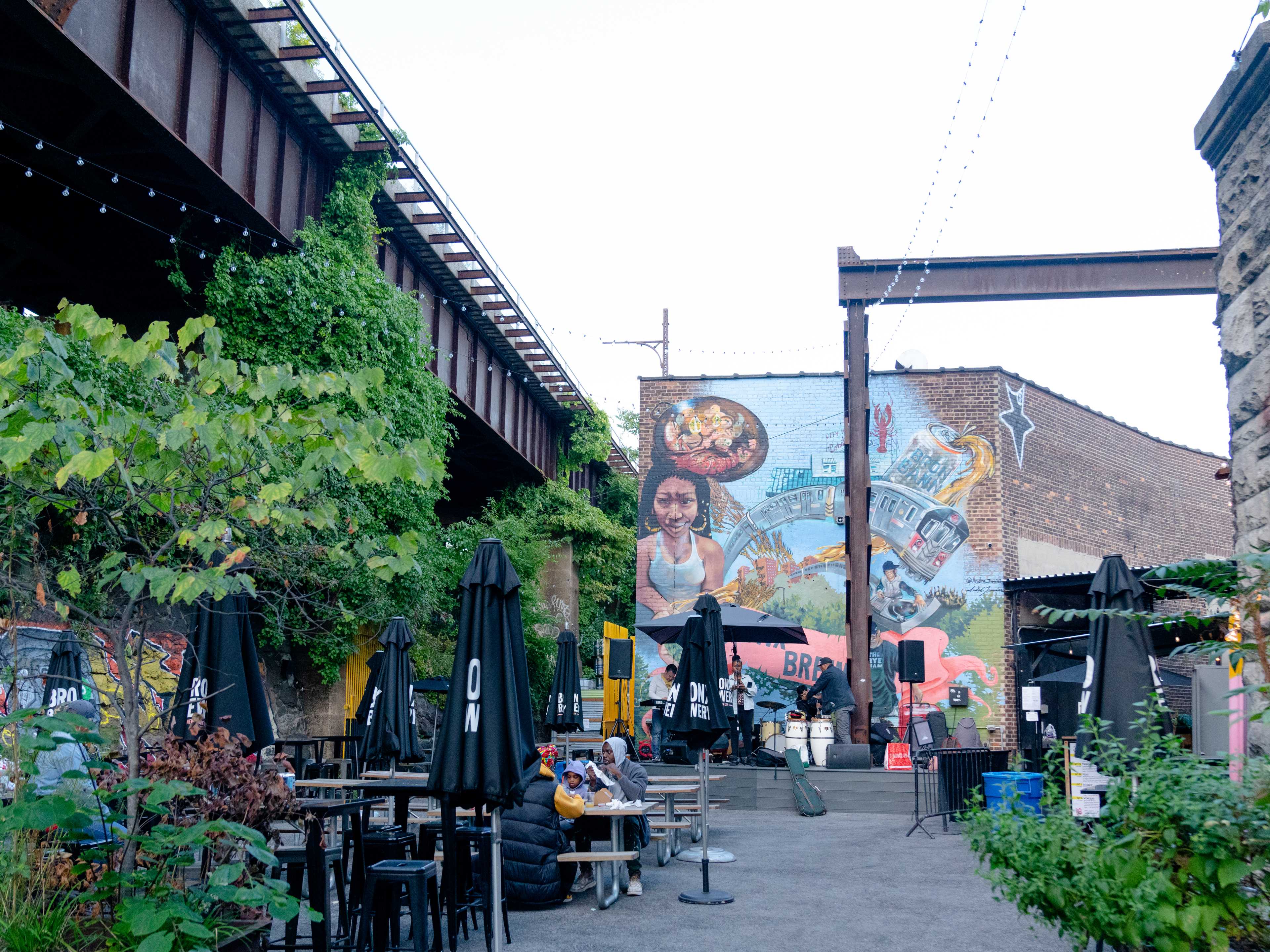 the exterior at bronx brewery, underneath a train and with a large mural