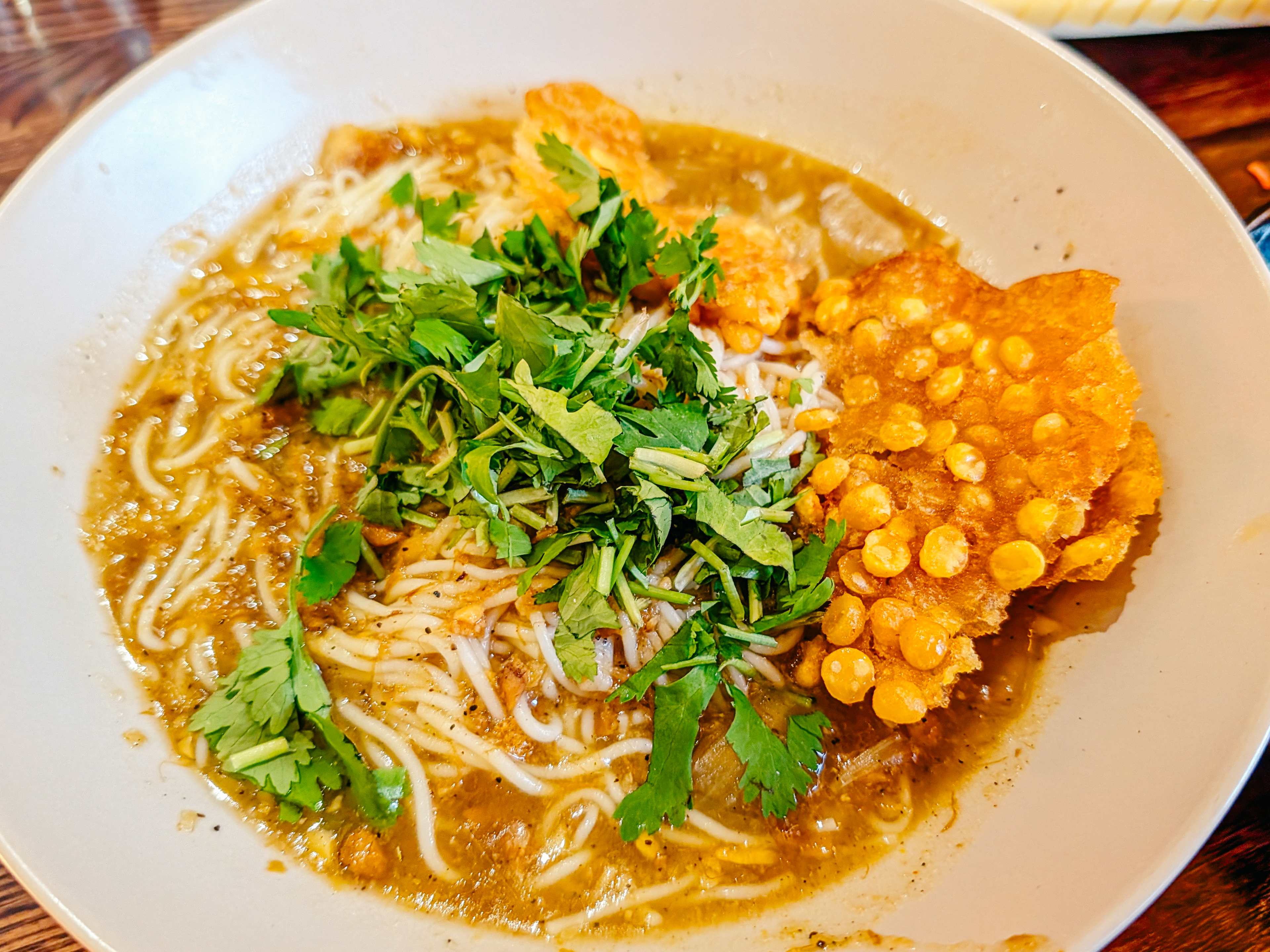bowl of mohinga with a lentil crisp