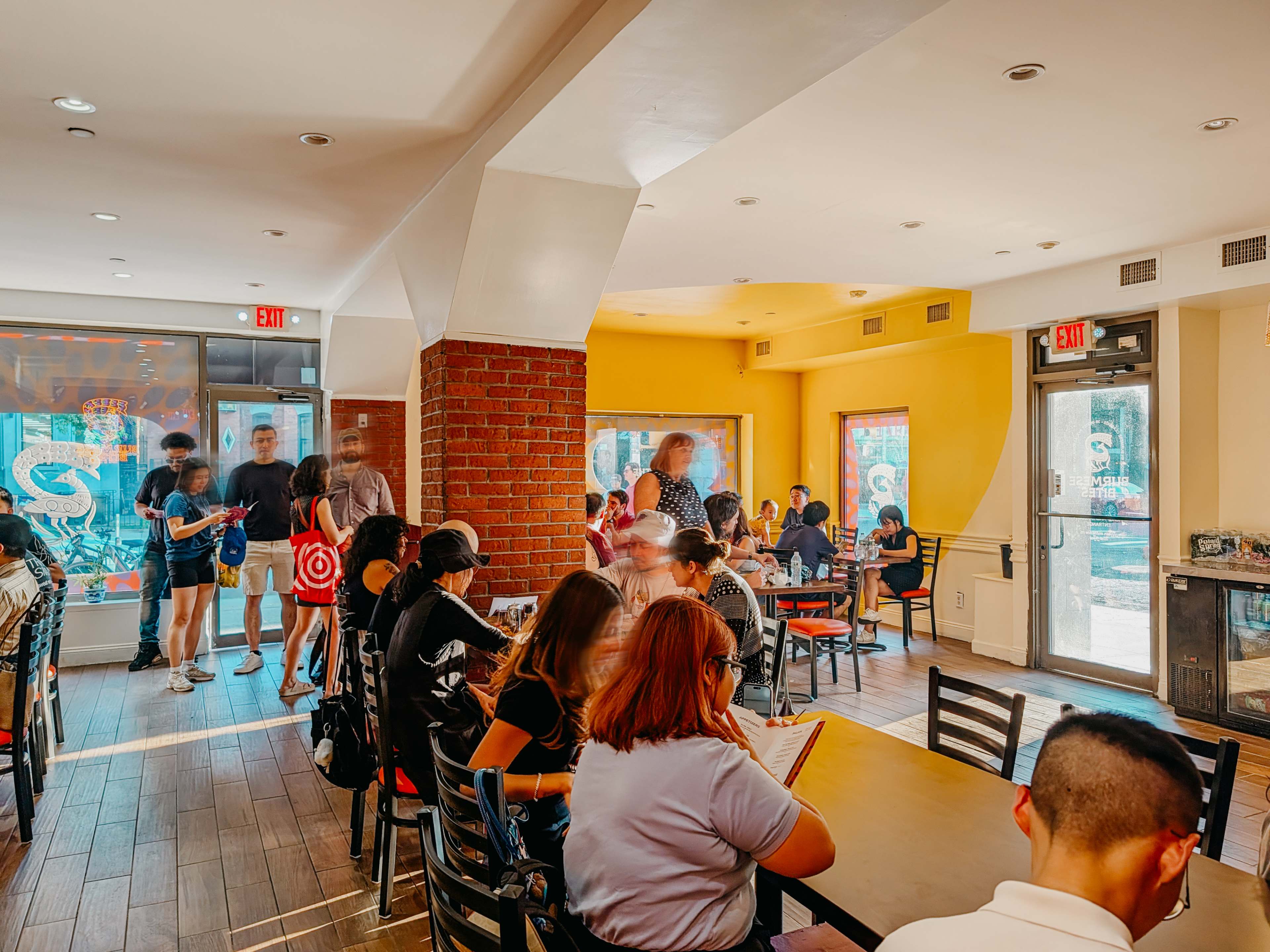 interior of restaurant with sunlight and people sitting on cafeteria style tables