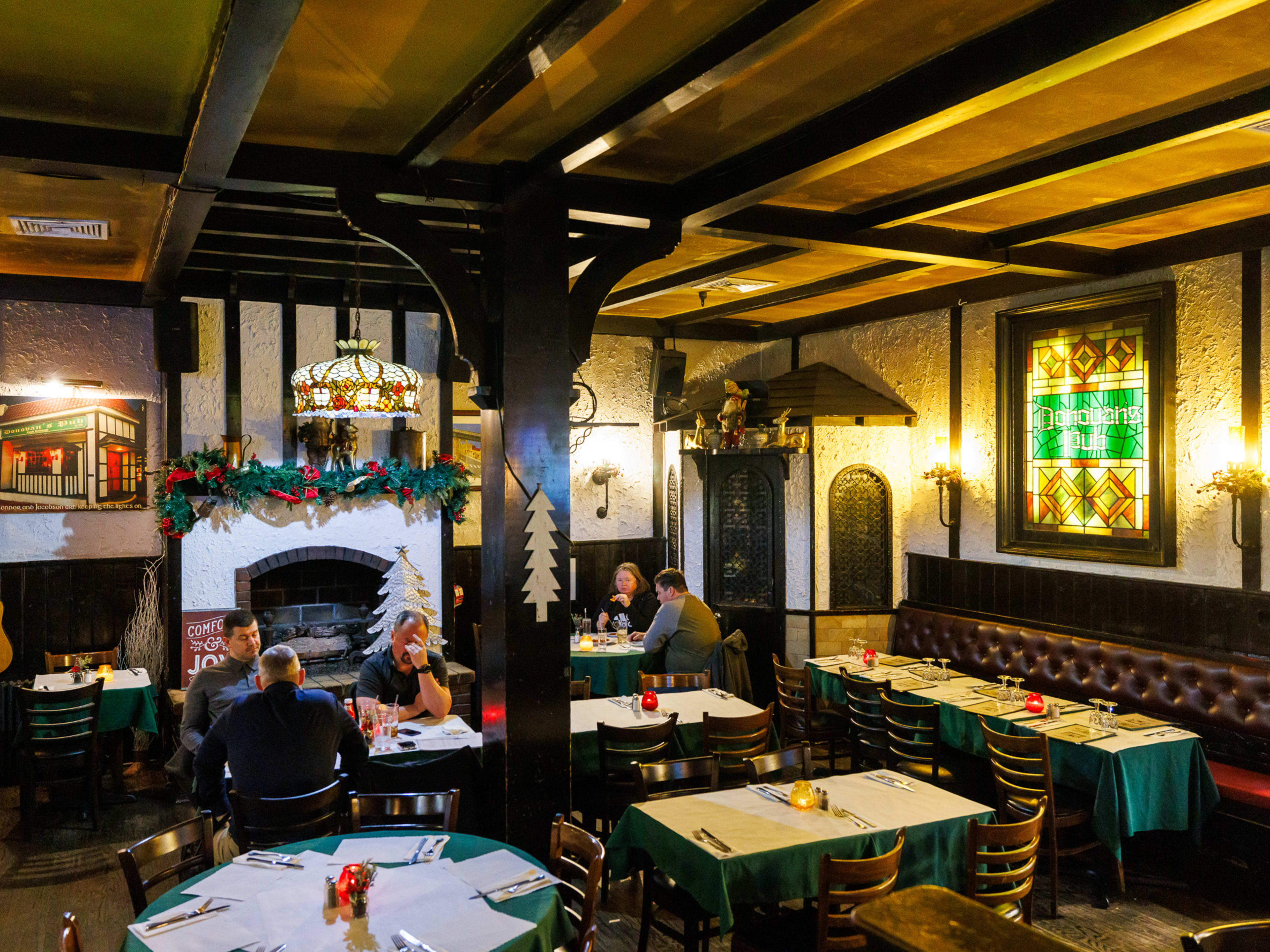 The dining area at Donovan's pub with tables, booths, and a fireplace with a guitar resting next to it.