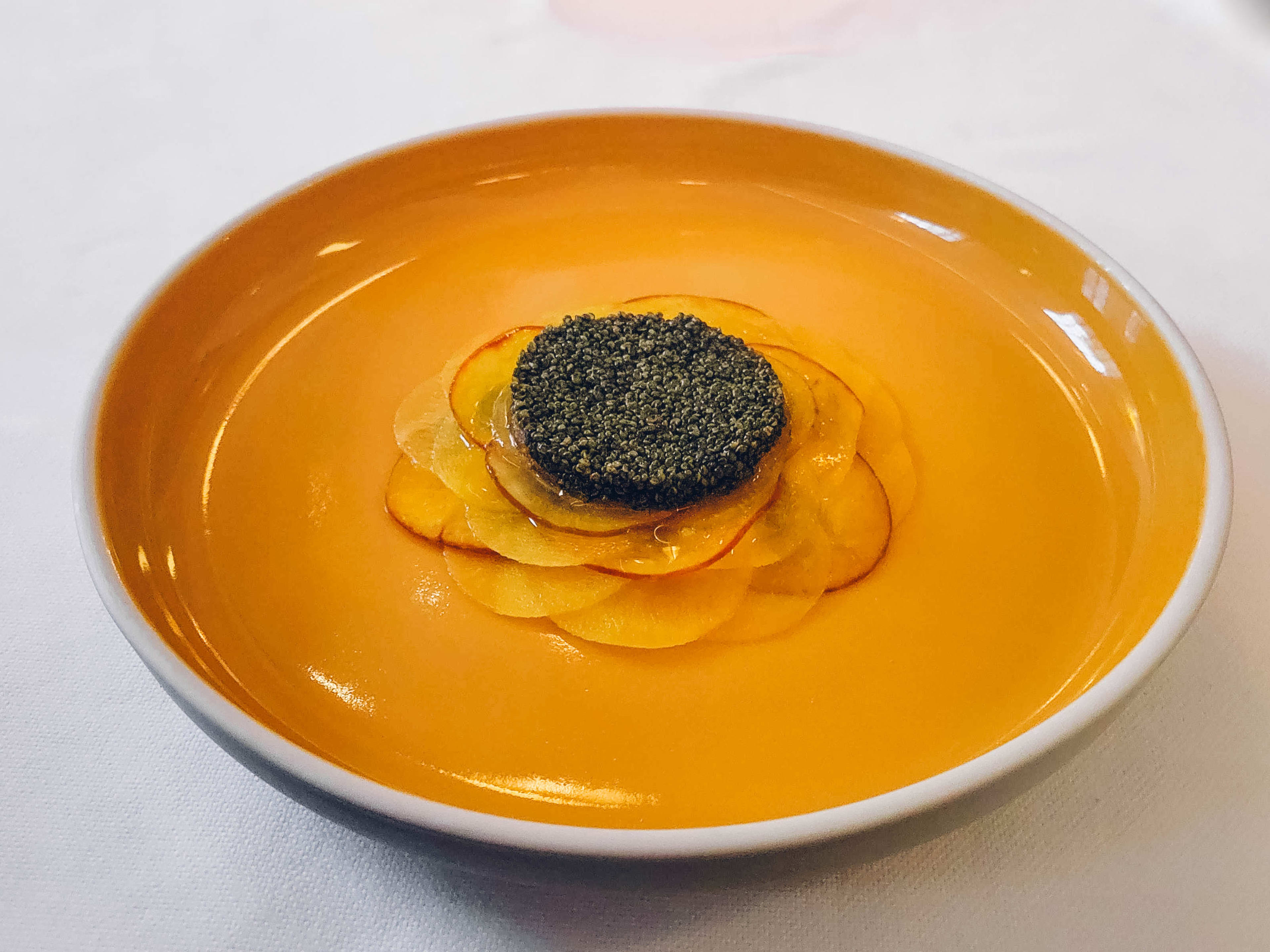 A neat pile of tiny dark brown seeds on top of orange sliced beets.