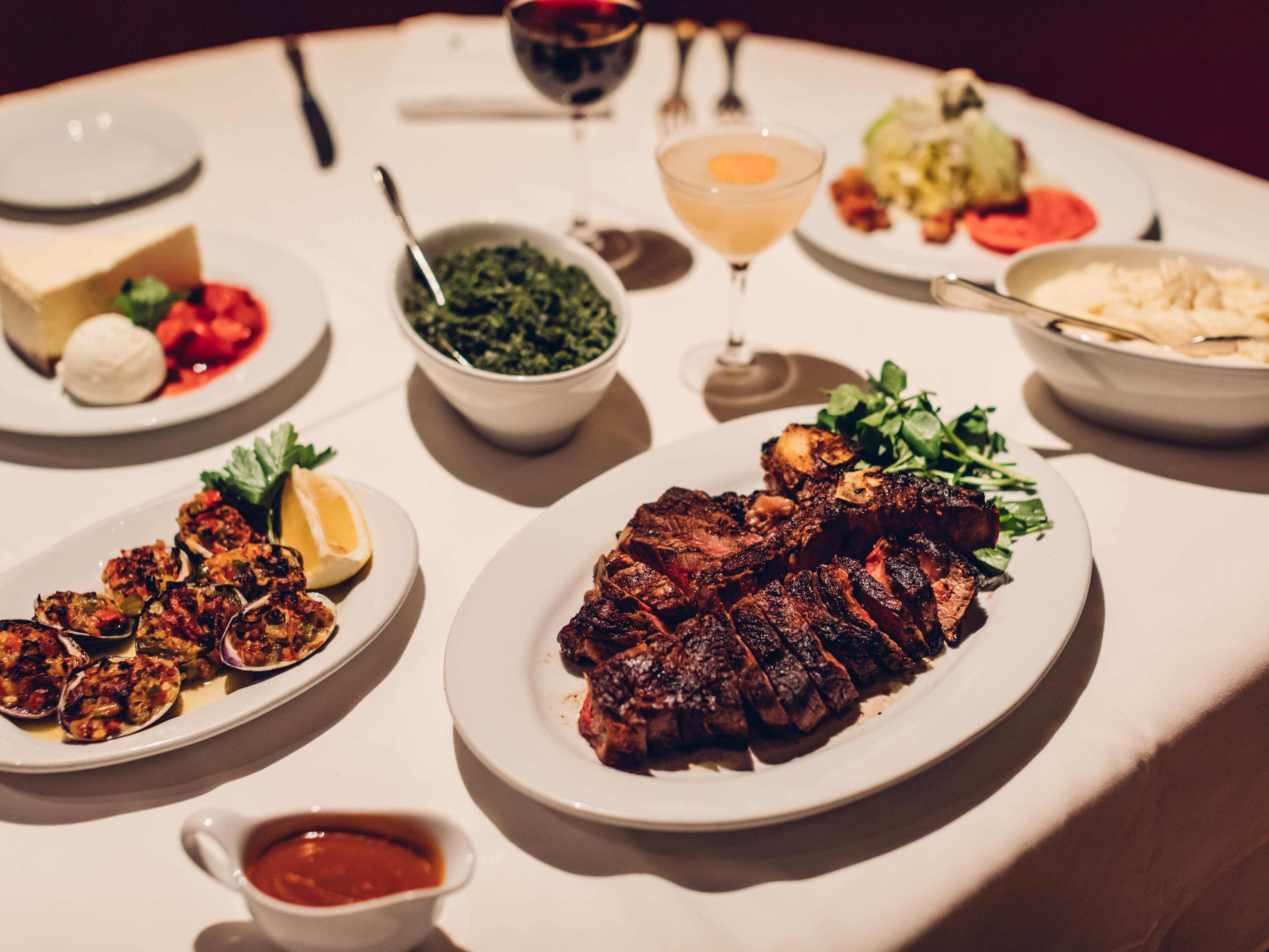 A slice porterhouse with sides on a table.