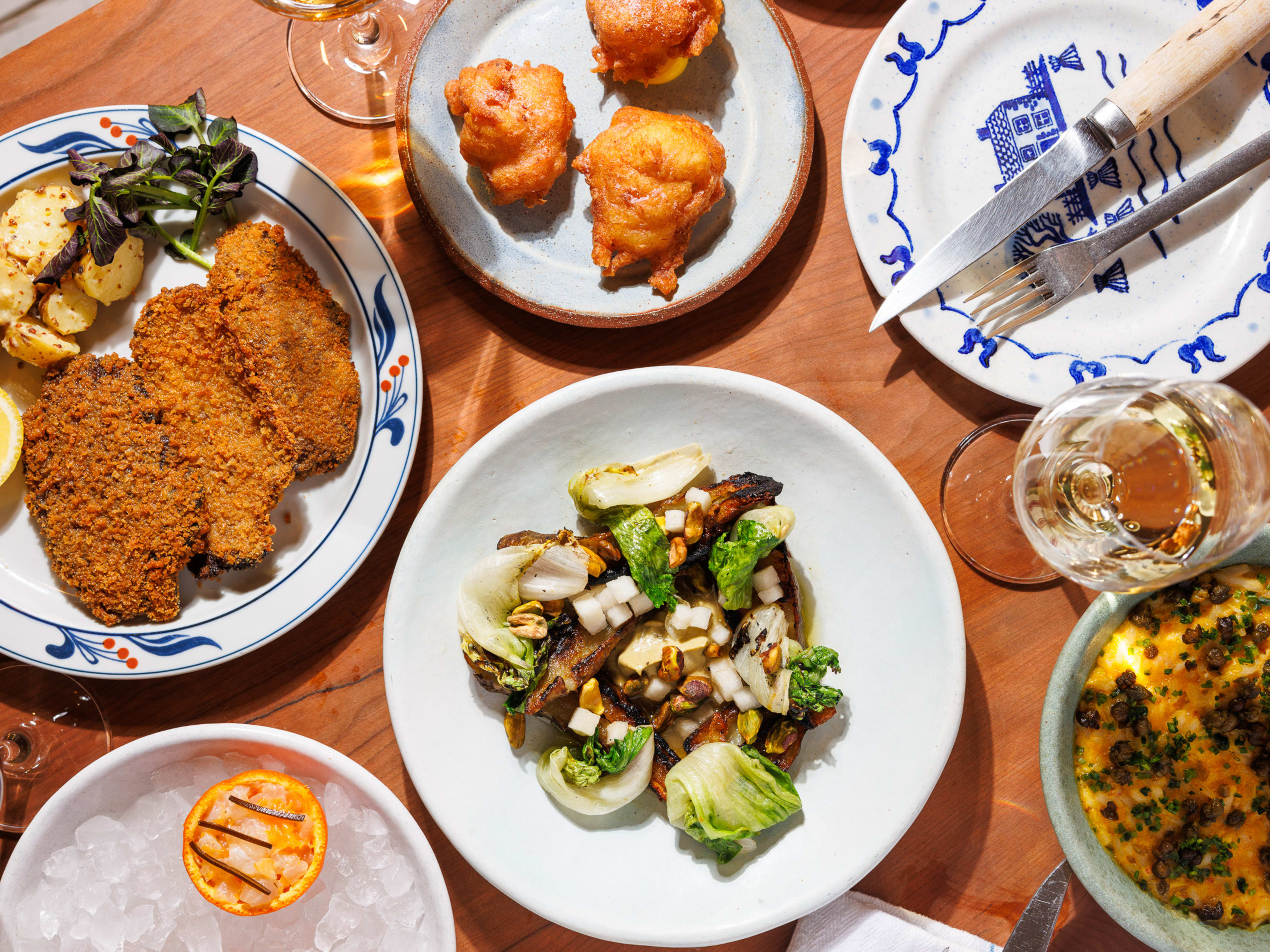 a spread of dishes at gem wine, including mushroom schnitzel, roasted sunchokes, a fluke crudo, and a salt cod beignet