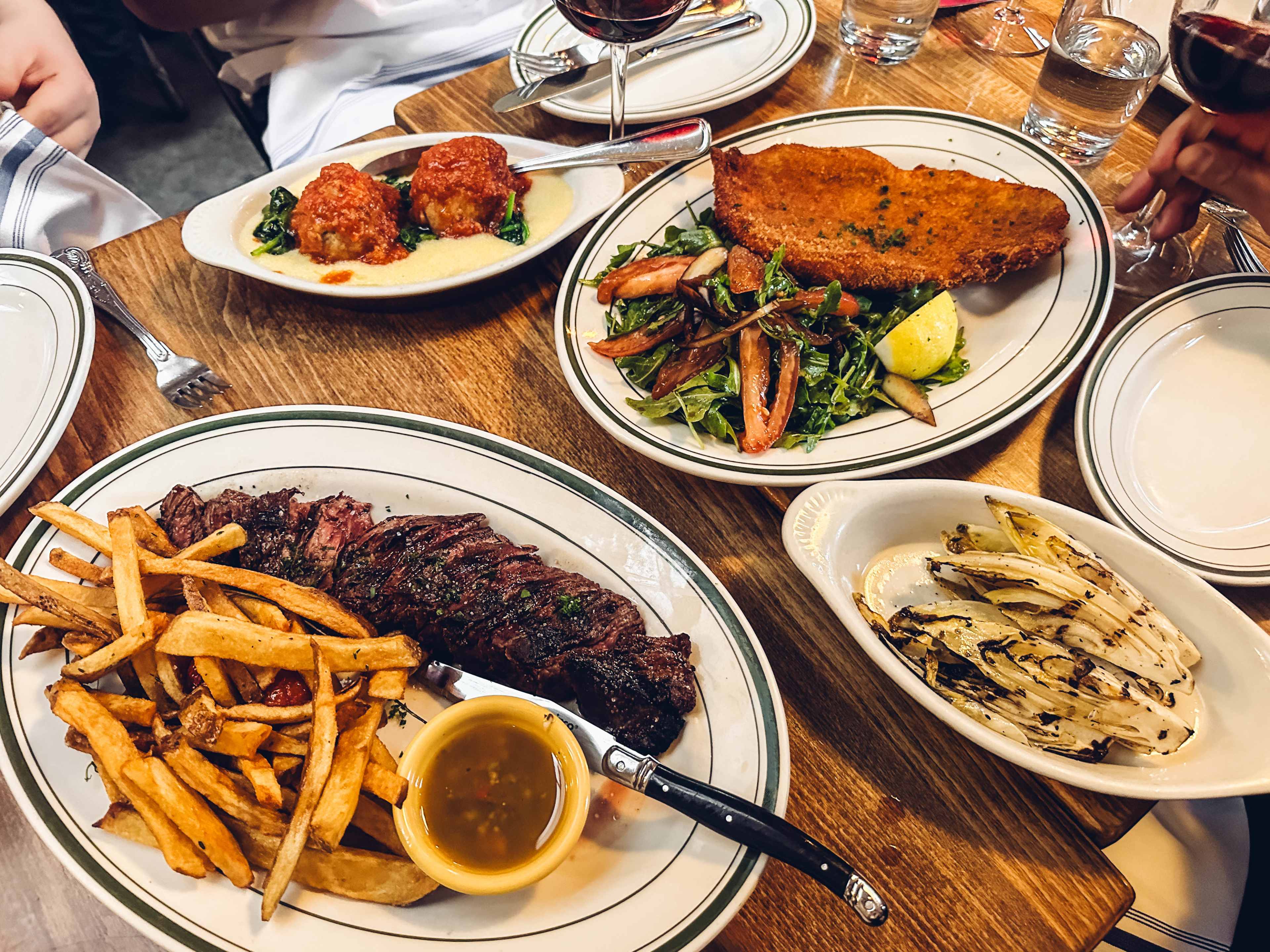 Bistecca and fries, grilled endive, meatballs and polenta, and chicken milanese at Go Nonna.