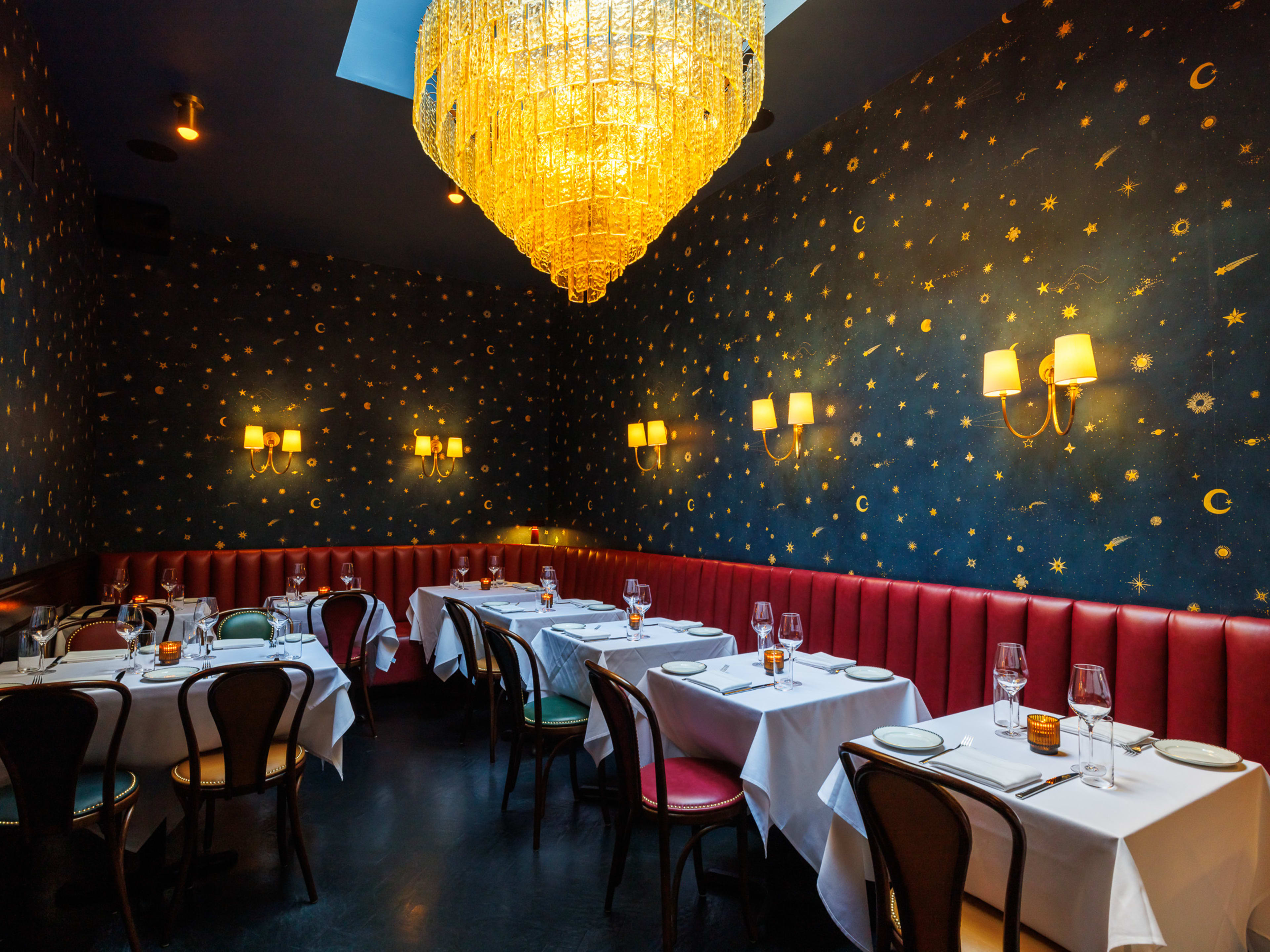 The dining room at Hoexter's, with a large chandelier and stars-and-moons wallpaper