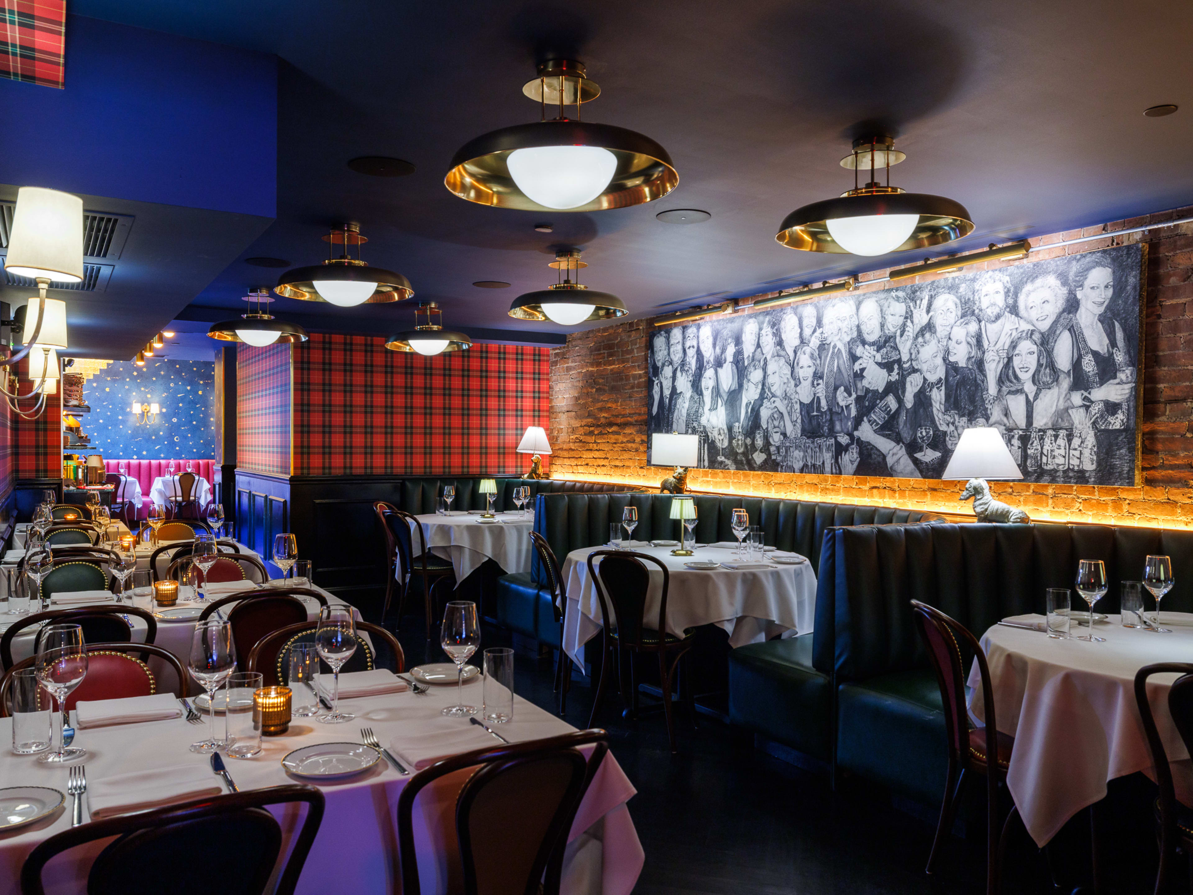 The lounge area at Hoexter's, with plaid wallpaper and a mural depicting a few famous faces in the neighborhood