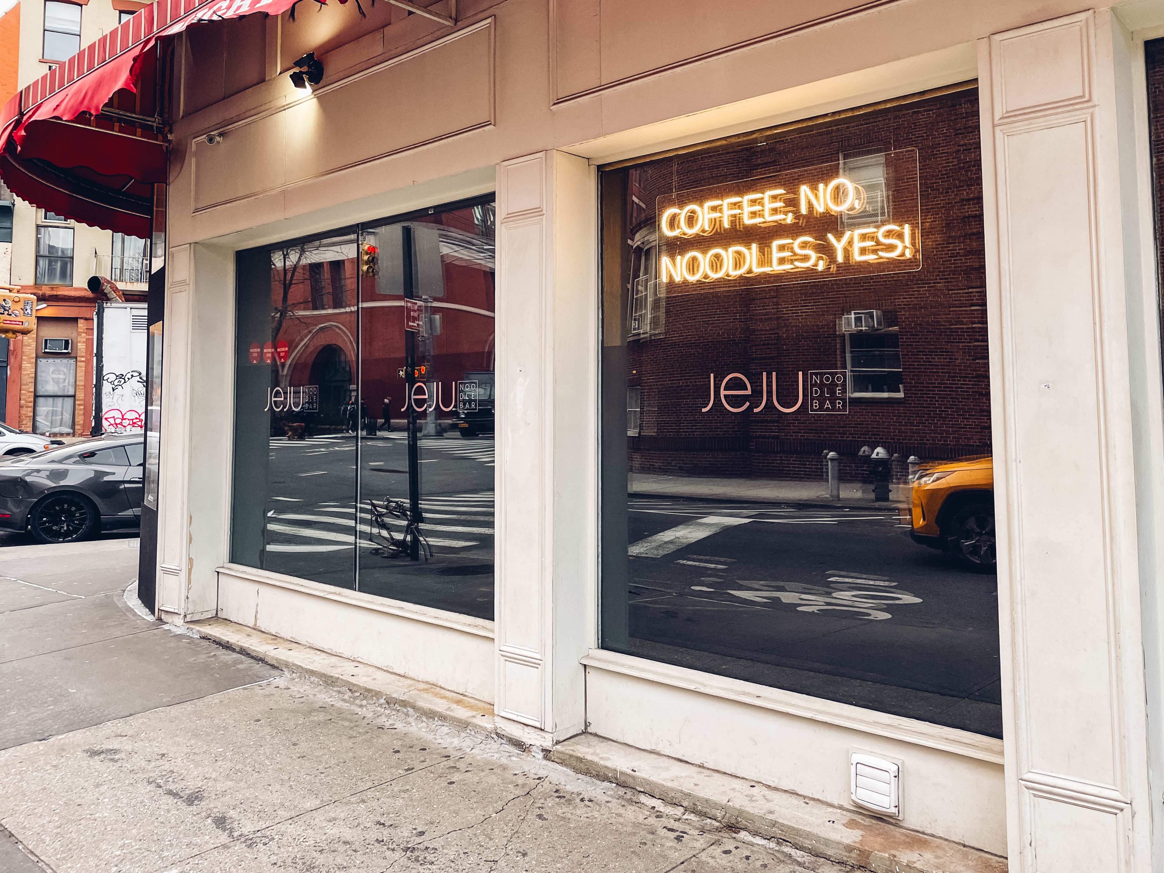 the exterior of jeju noodle bar, which has a neon sign that says "Coffee, no, Noodles, Yes!"