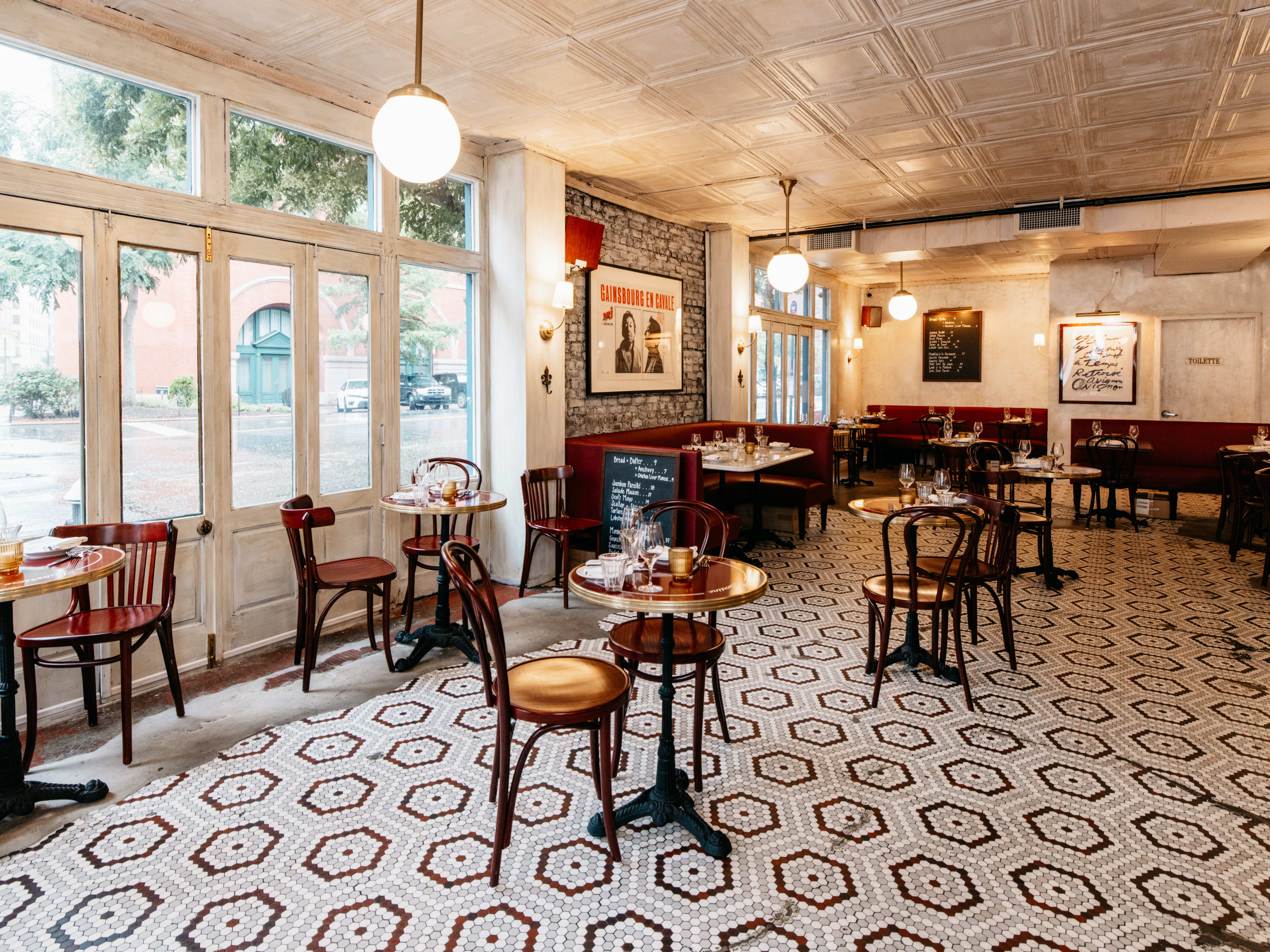 A bistro dining room with tiled floors and globe lamps hanging from the ceiling.