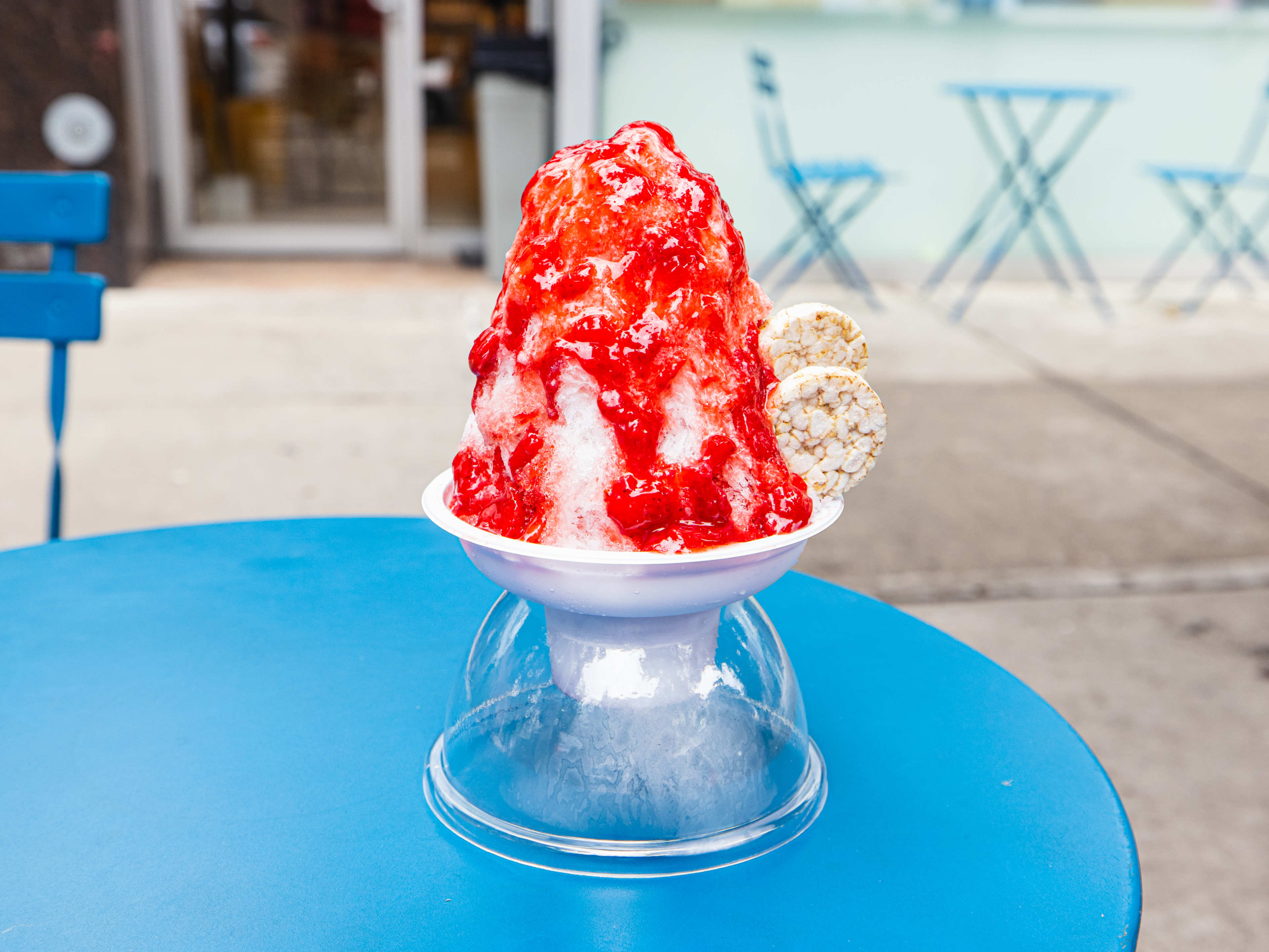 a bowl of tall kakigori with a bright red syrup over the top