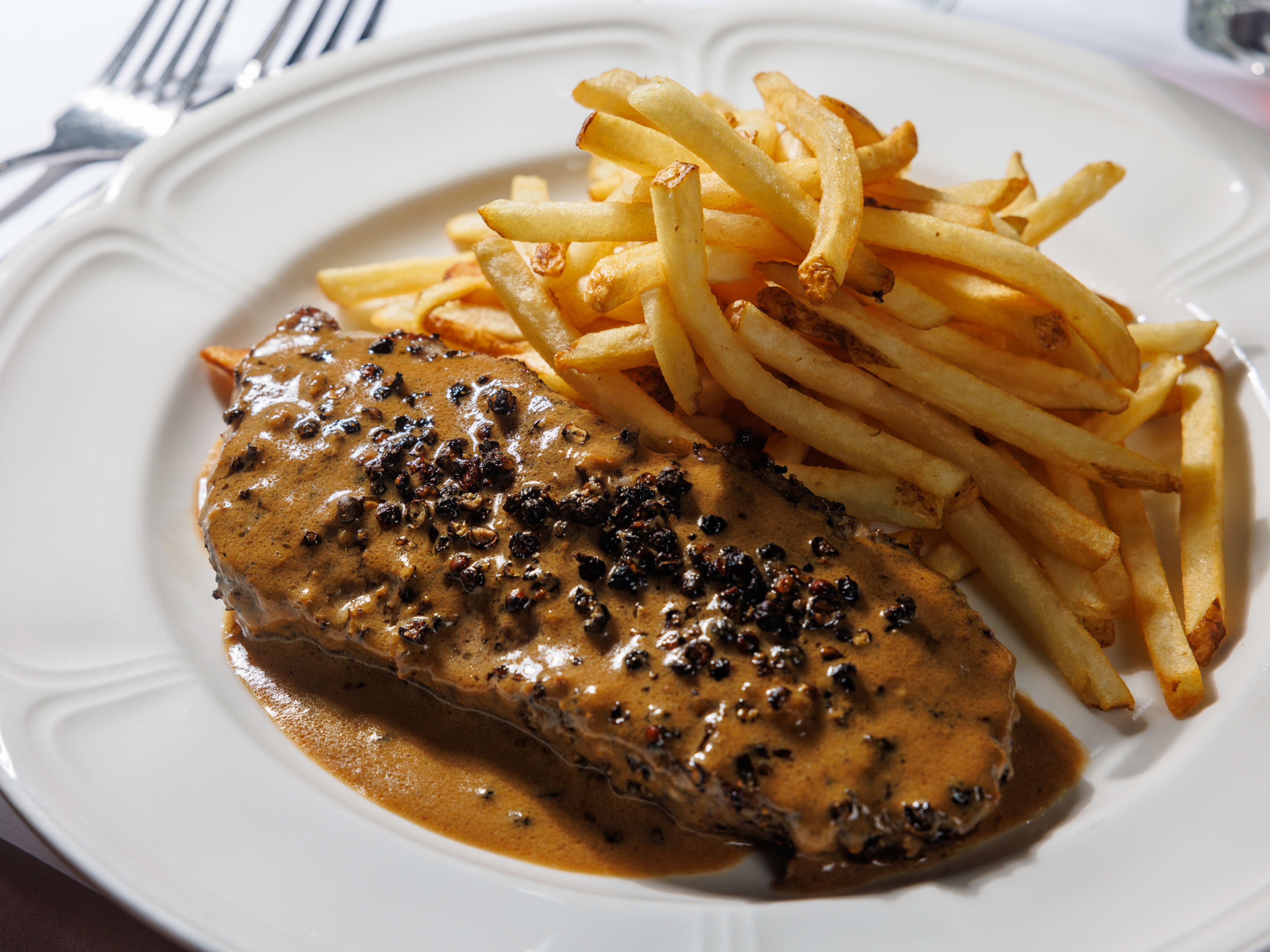 Steak au poivre with a pile of fries on the side.