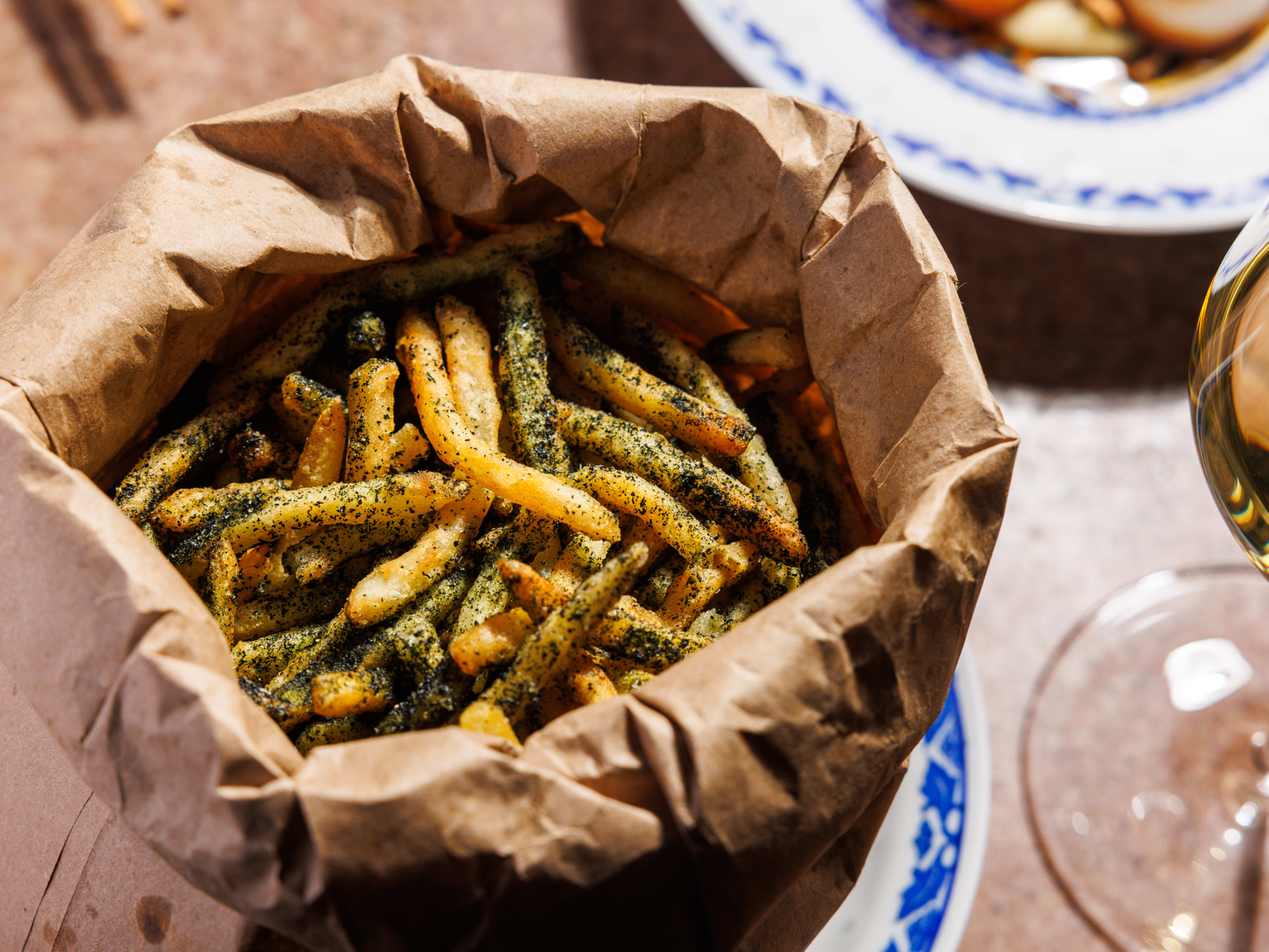 a brown paper bag full of french fries