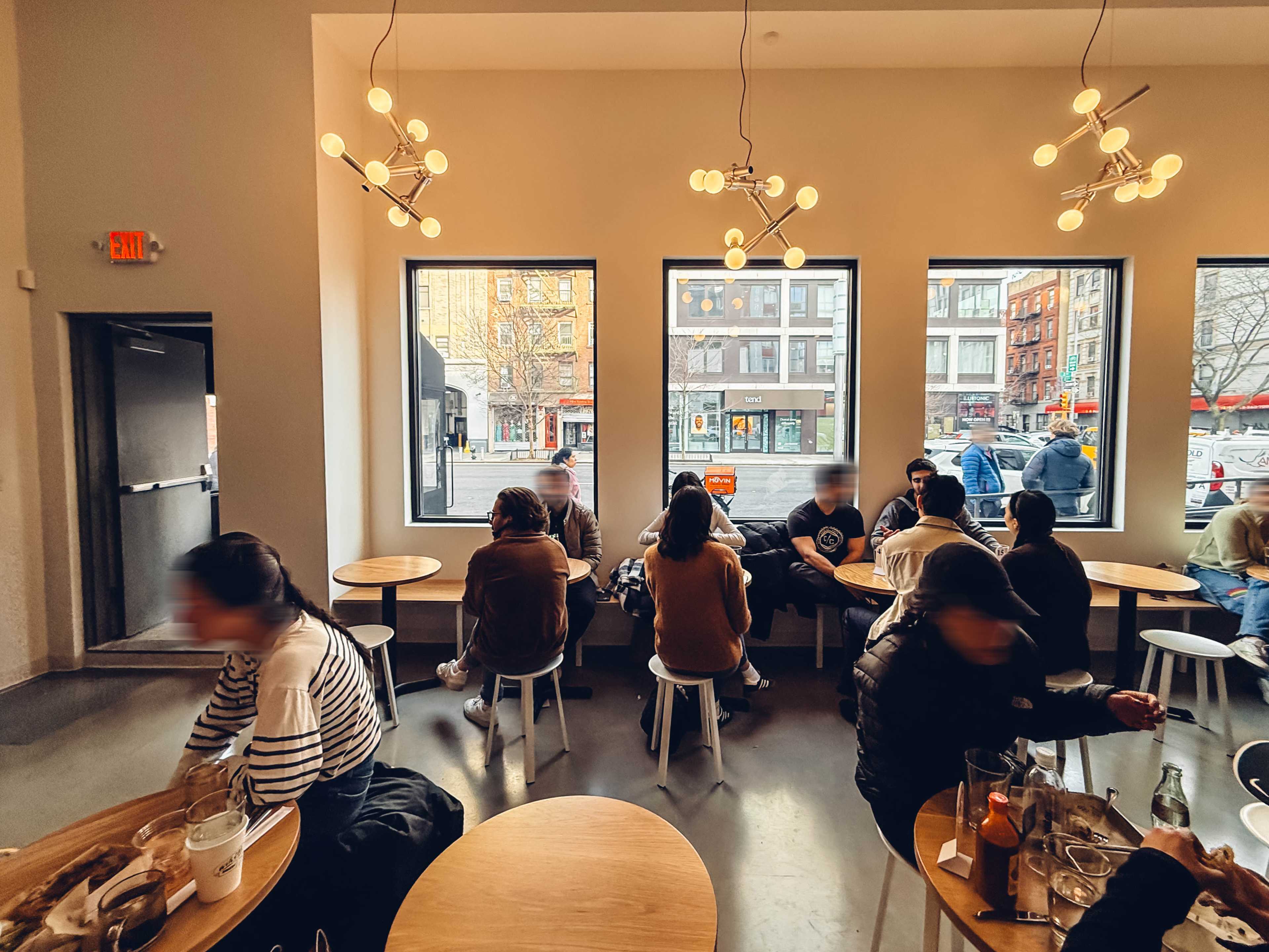 A small, casual dining room with a few rows of round tables.