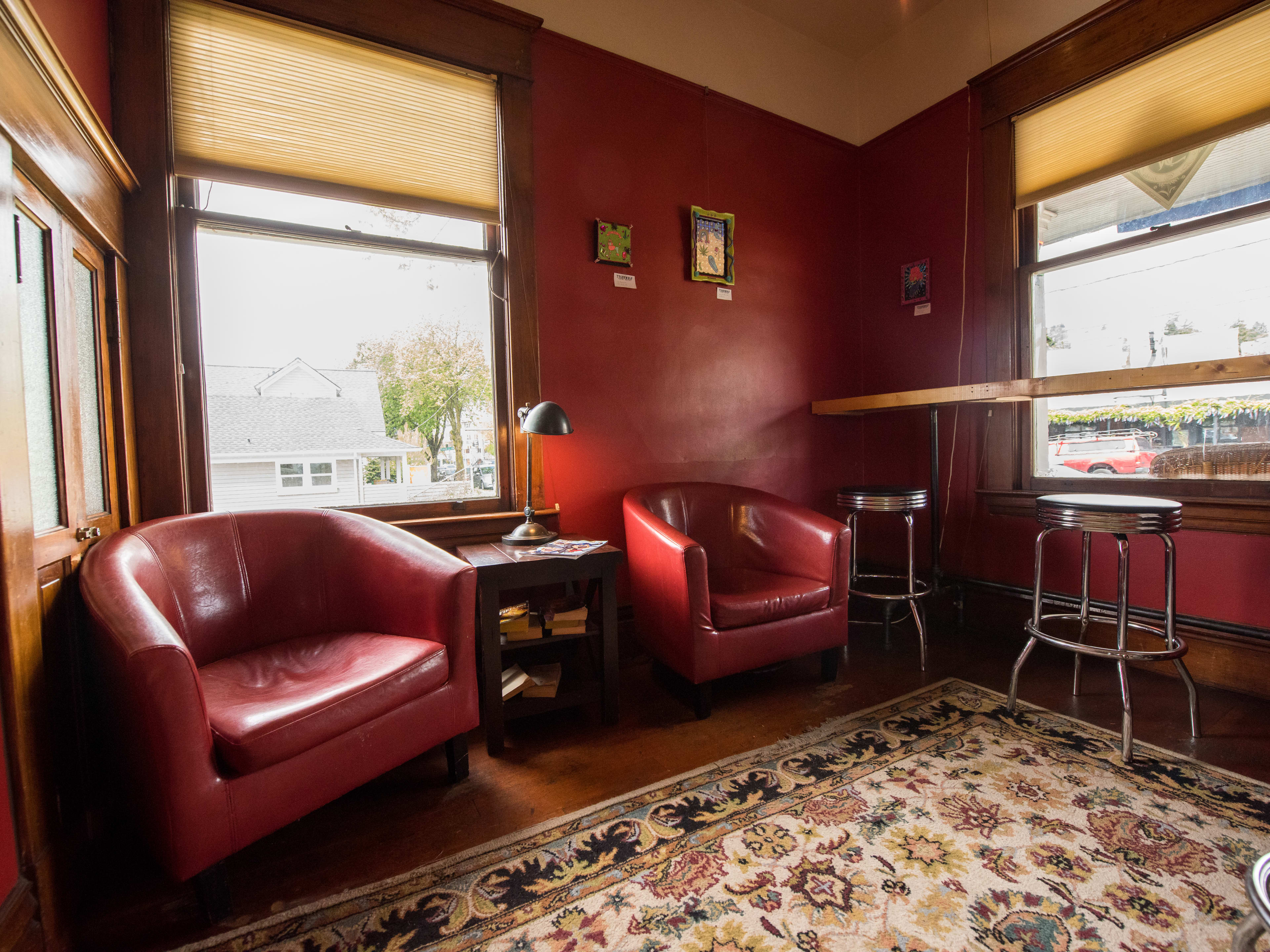 Living room-style coffee shop room with diner-style barstools and leather armchairs