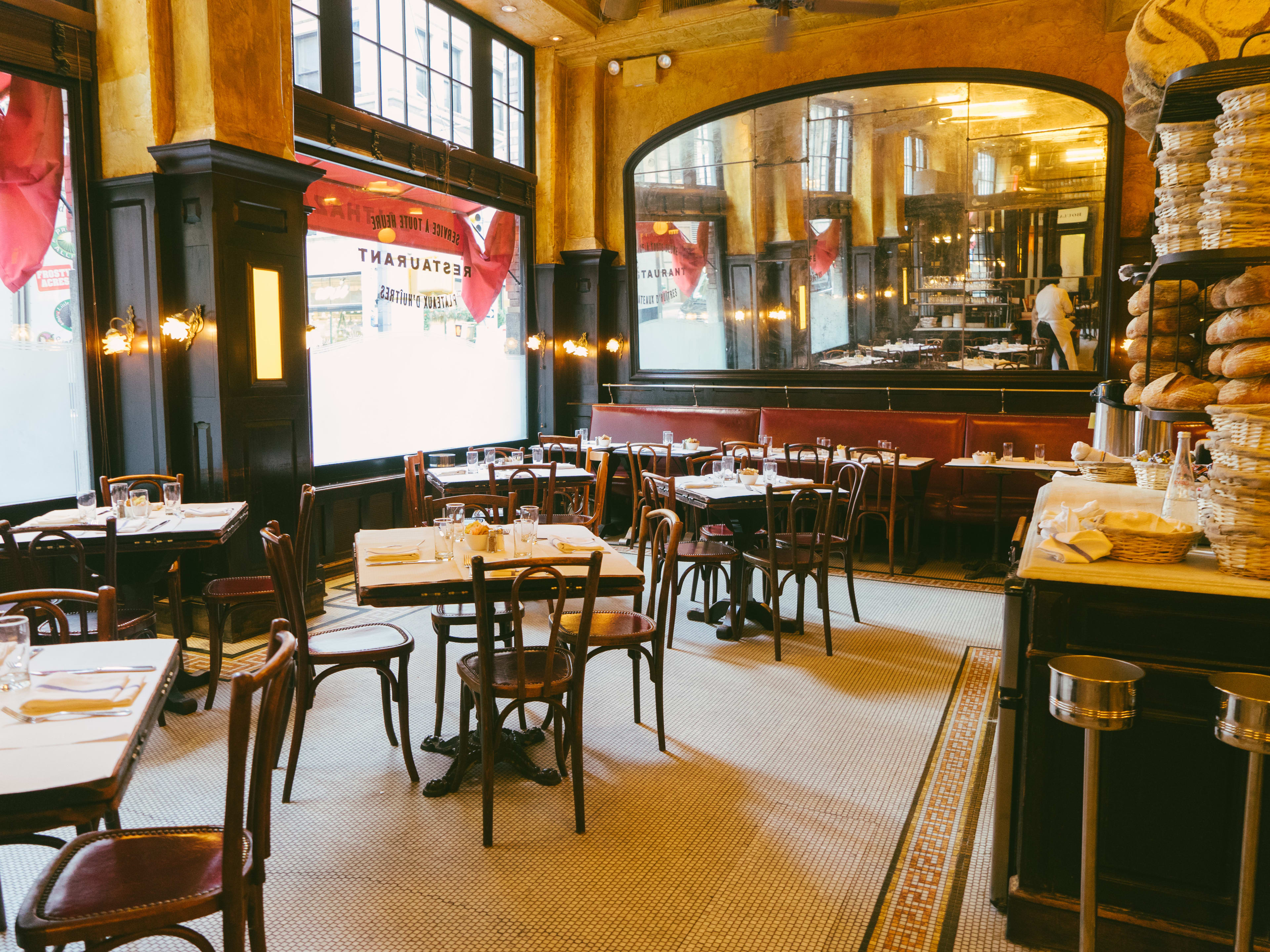 A big, classic French brasserie with burgundy banquettes and mirrors on the walls.