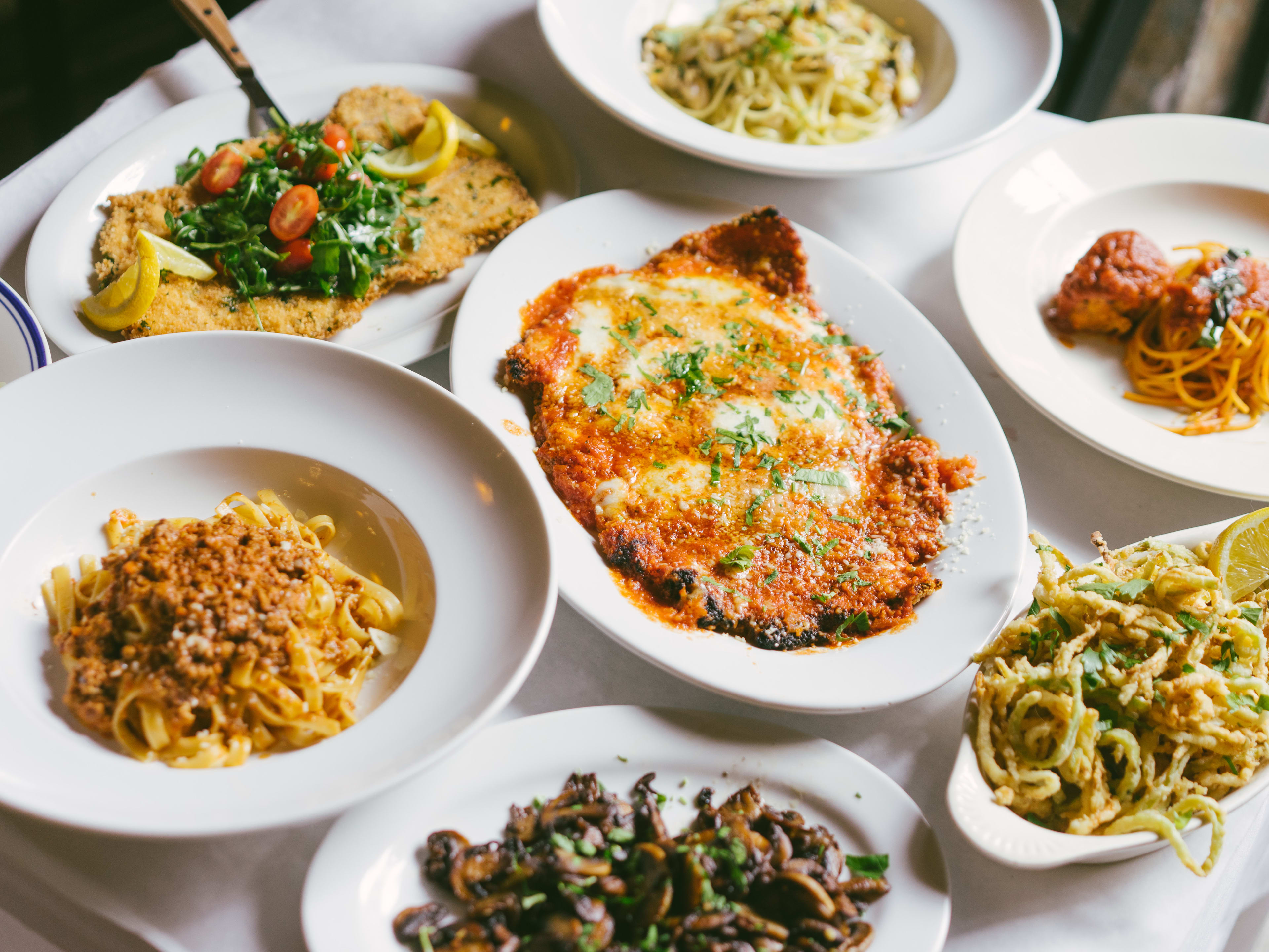 A big spread of red sauce Italian food, including fritto misto, pasta, and veal parm.