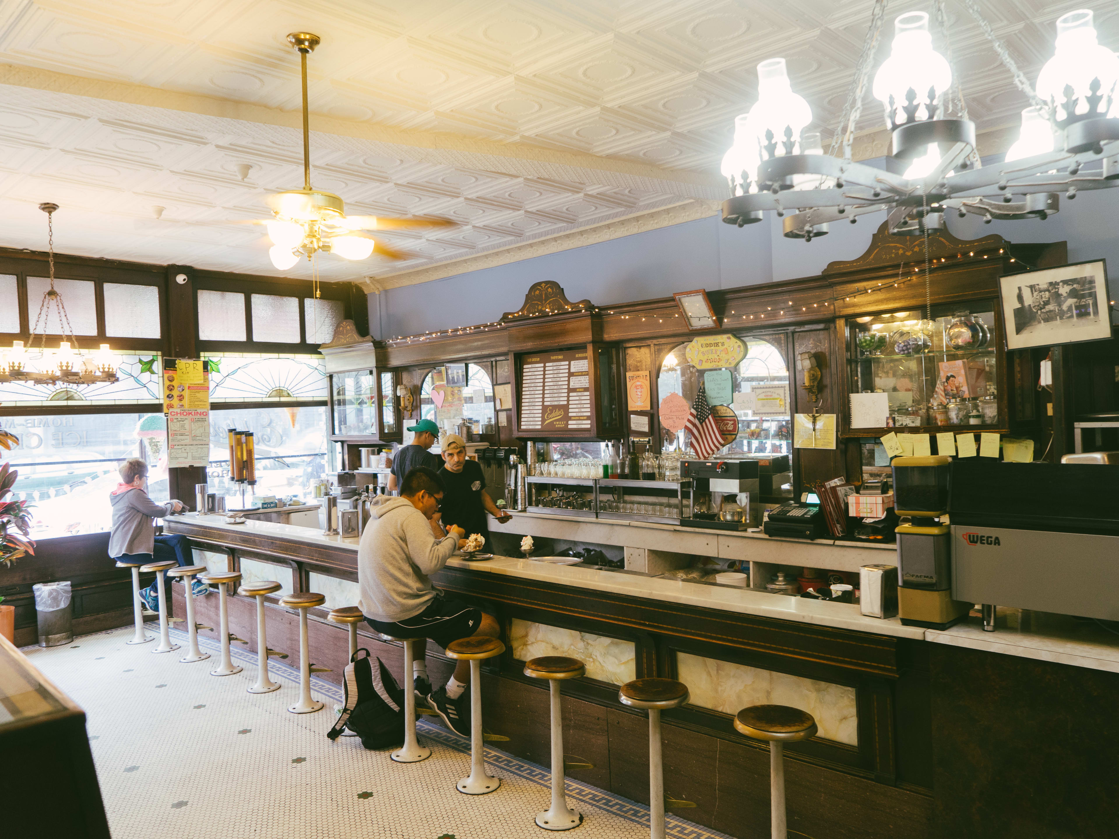 People sitting at the ice cream bar eating sundaes at Eddie’s Sweet Shop.