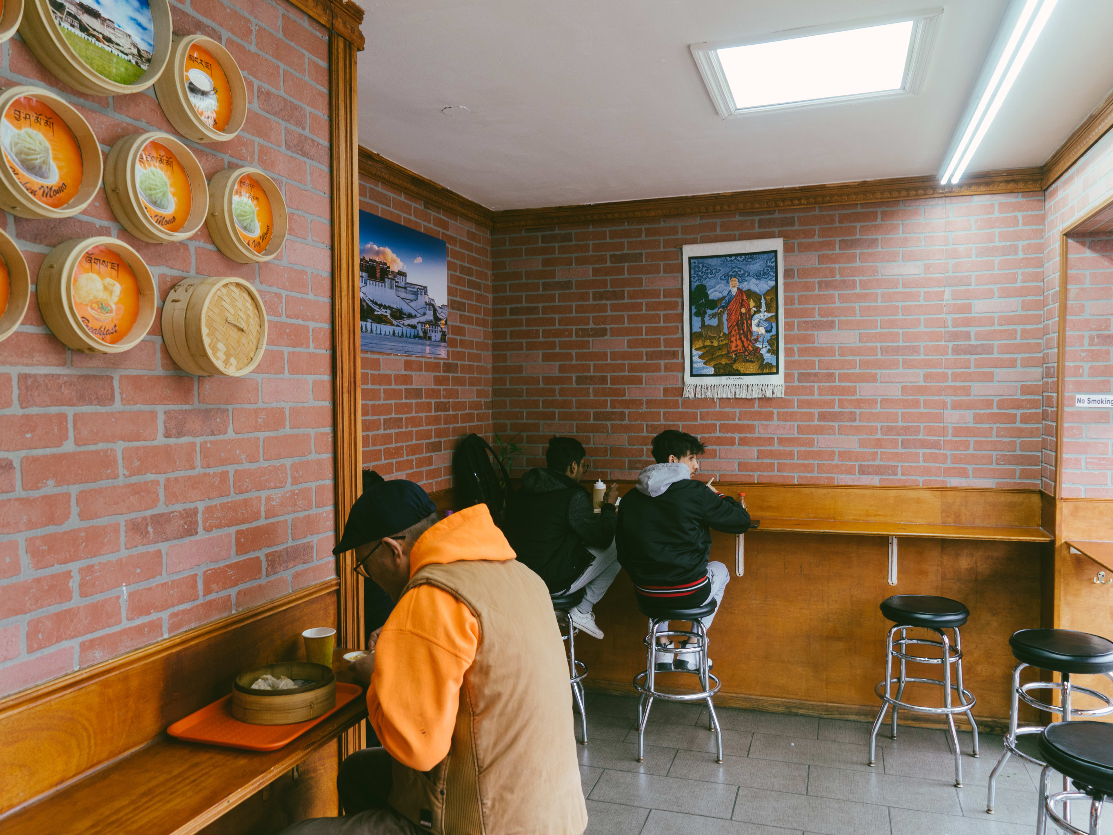 People sit at a wrap around counter to eat at Potala.