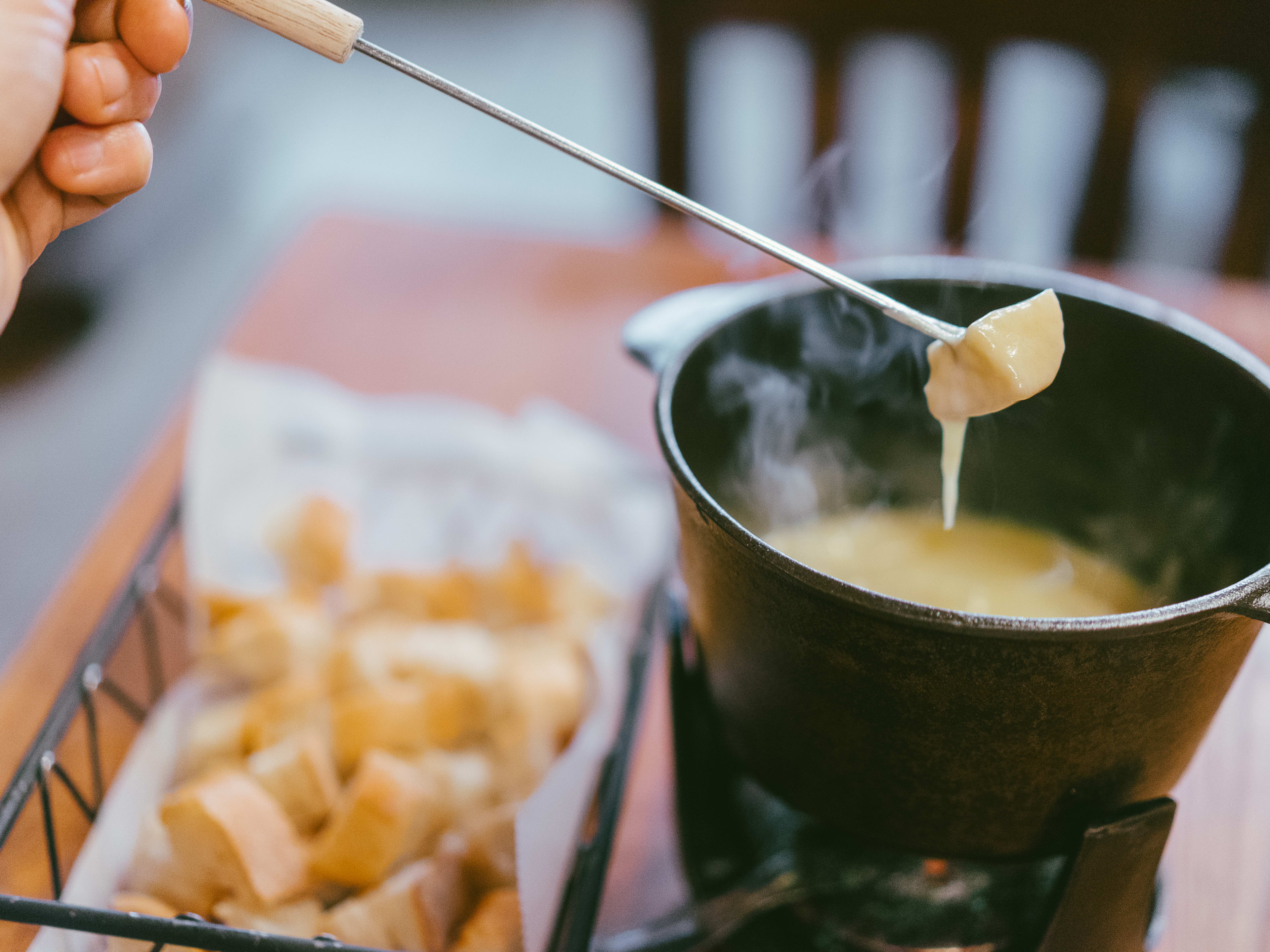 A person dips bread in a fondue pot at Kashkaval Garden.