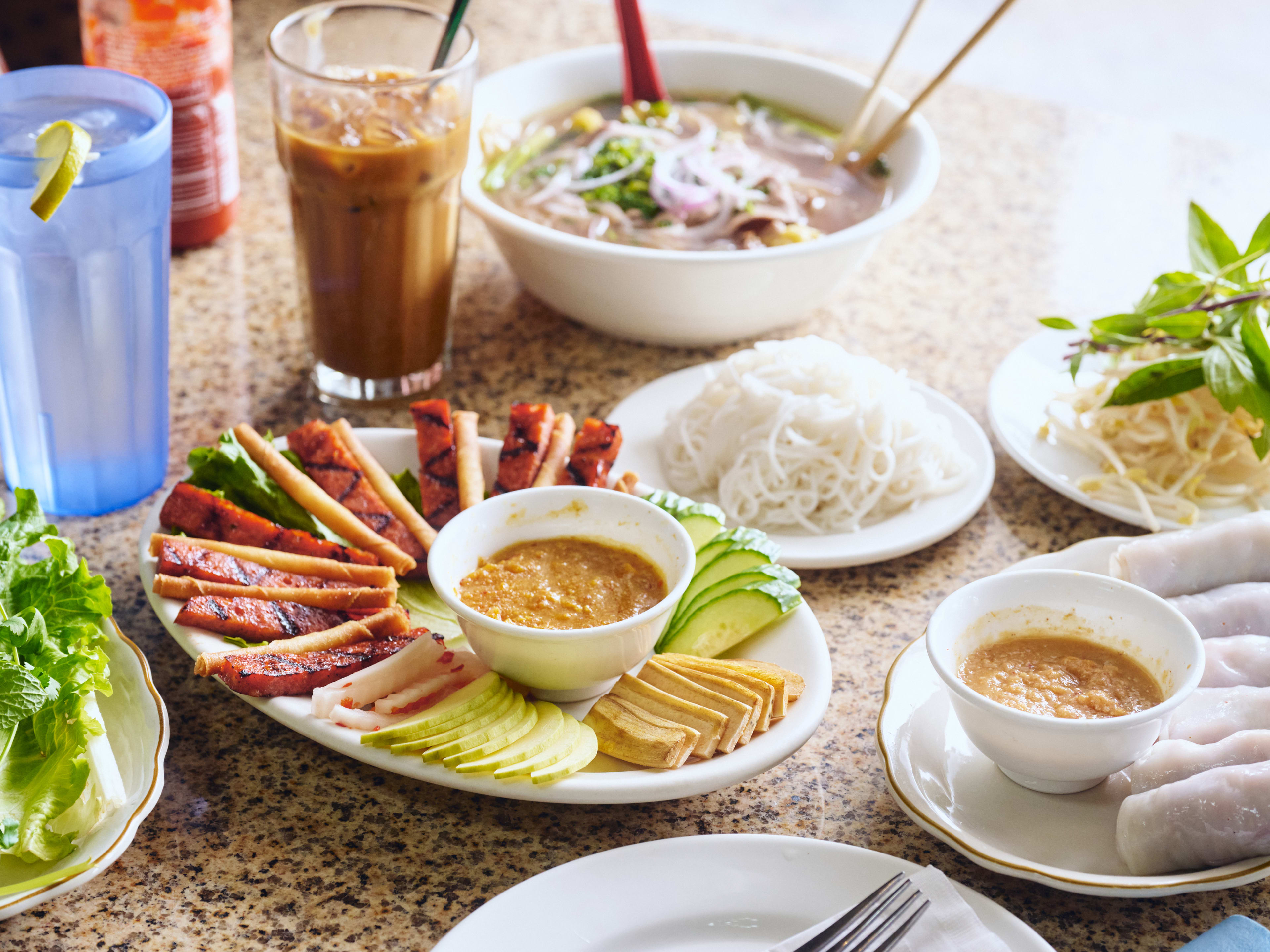 Spread of Vietnamese dishes and Vietnamese iced coffee at Ba Mien