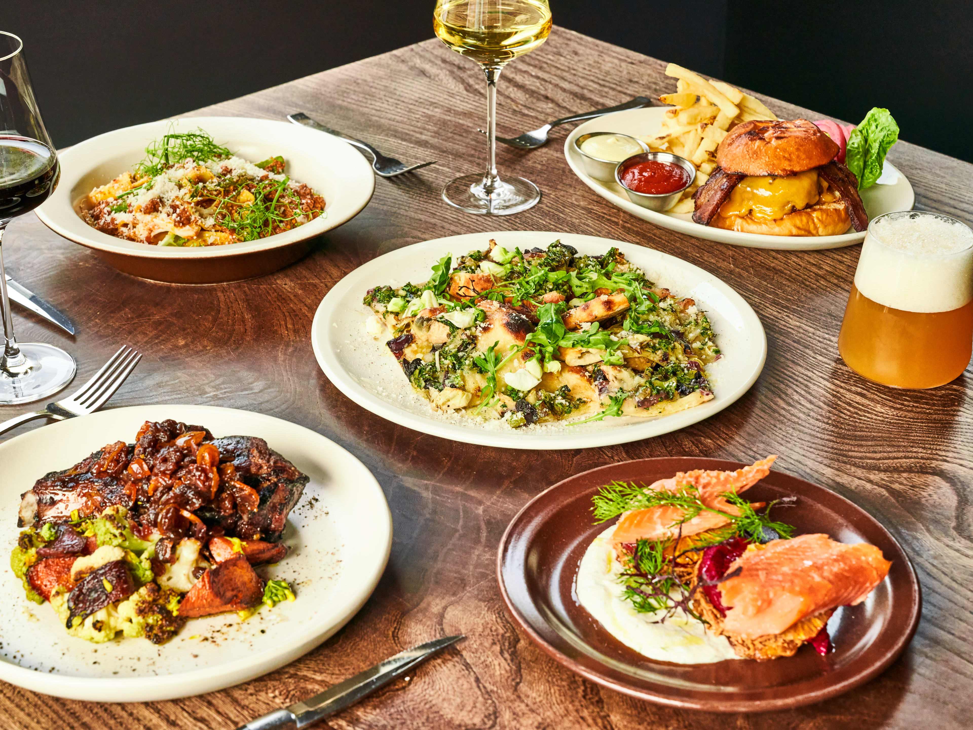 A spread of flatbread, the burger, latkes, and the pork chop at Nopa