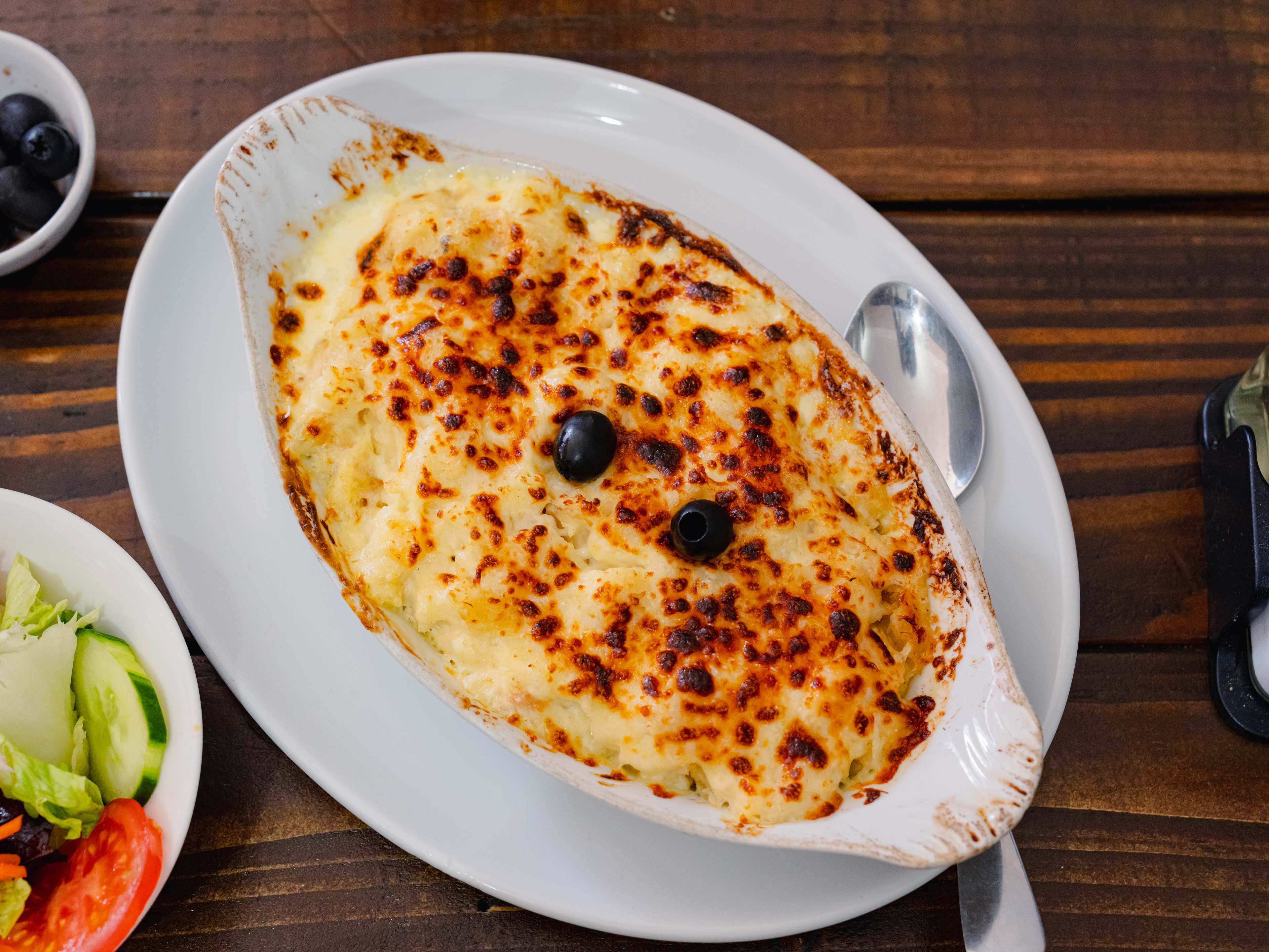 Overhead shot of a white dish with bacalhau com natas.